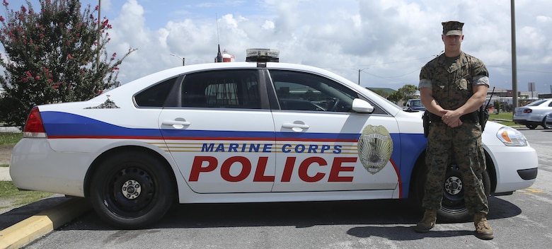 Cpl. Wyatt Ray poses with his patrol car aboard Marine Corps Air Station Cherry Point, N.C., Aug. 3, 2016. Ray is a military policeman assigned to MCAS Cherry Point. (U.S. Marine Corps photo by Lance Cpl. Cody Lemons/Released)