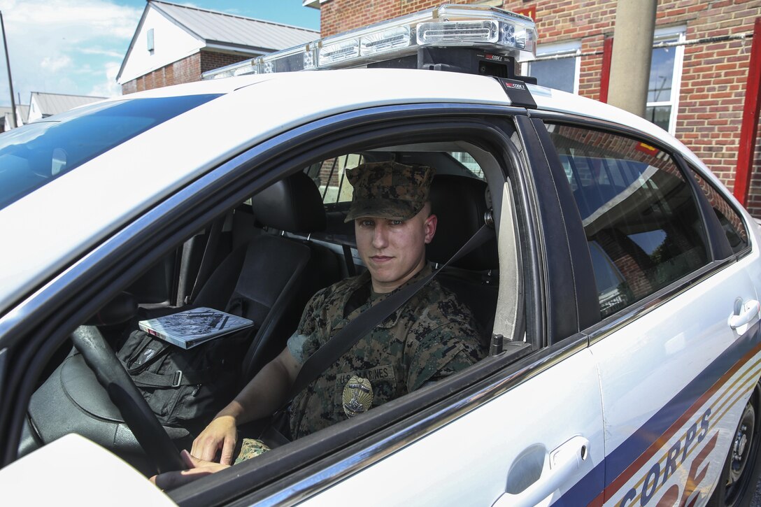 Cpl. Wyatt Ray poses with his patrol car aboard Marine Corps Air Station Cherry Point, N.C., Aug. 3, 2016. Ray is a military policeman assigned to MCAS Cherry Point. (U.S. Marine Corps photo by Lance Cpl. Cody Lemons/Released)