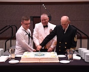 Seaman Charles Diehl (left), Navy Nuclear Power Training Command machinist mate, Master Chief Petty Officer Asa Worcester (center), Joint Base Charleston command master chief and Sam Kirton, a retired Navy Master Chief Petty Officer, cut the cake during the Navy Ball celebrating the Navy’s 241st birthday. The event took place at the Embassy Suites Hotel, Charleston, South Carolina on Oct. 15. Navy tradition is to have the cake cut by the youngest and oldest Navy members present.