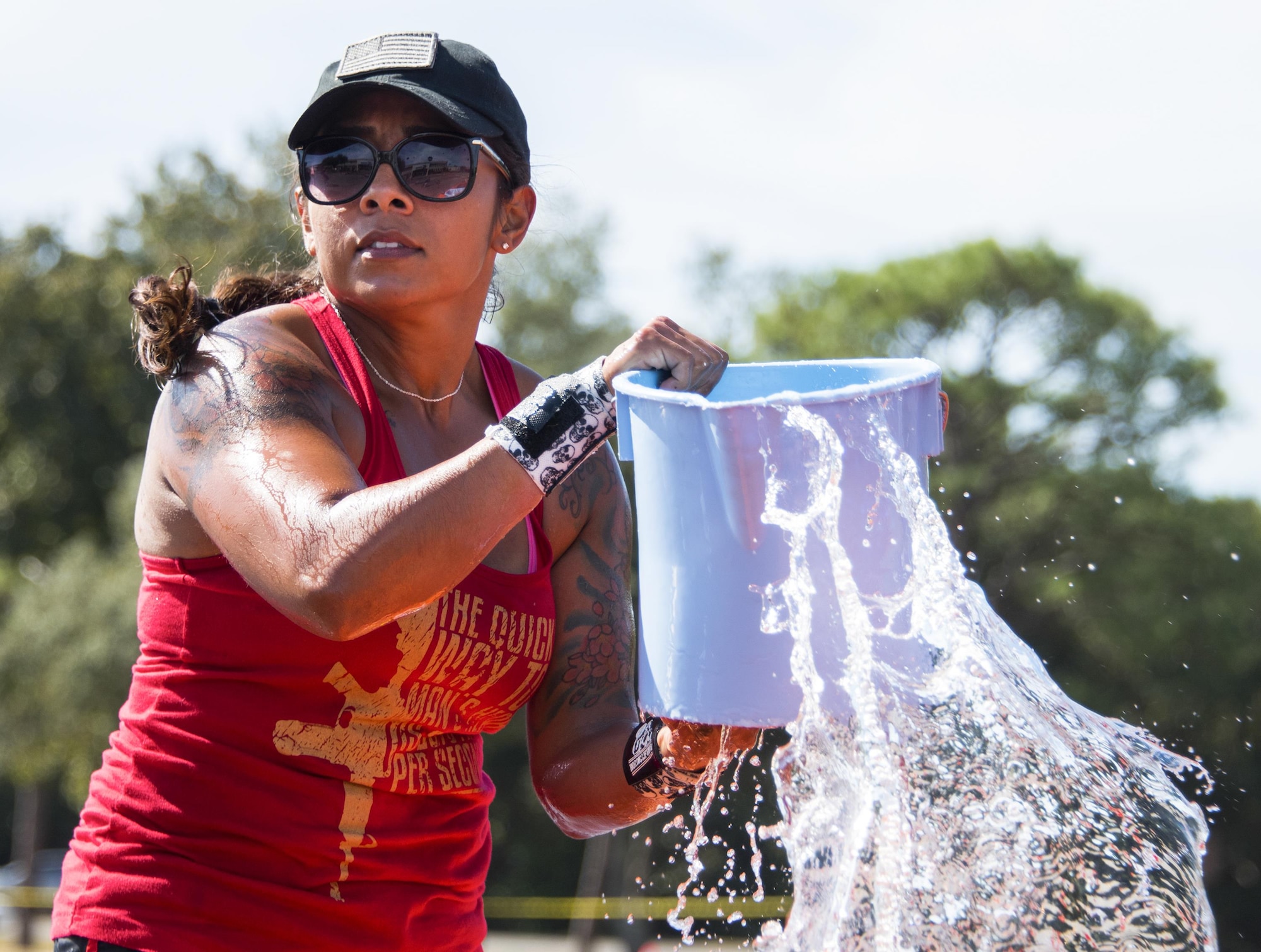 A 86th Fighter Weapons Squadron team member lifts up a holy bucket of water from the pool during the fire muster challenge Oct. 14 at Eglin Air Force Base, Fla.  Approximately seven teams competed for the best time in the annual event that included shooting and rolling up the fire hose, hammer sled, victim-carry and water relay. The challenge closed out the base’s Fire Prevention Week activities. (U.S. Air Force photo/Samuel King Jr.)
