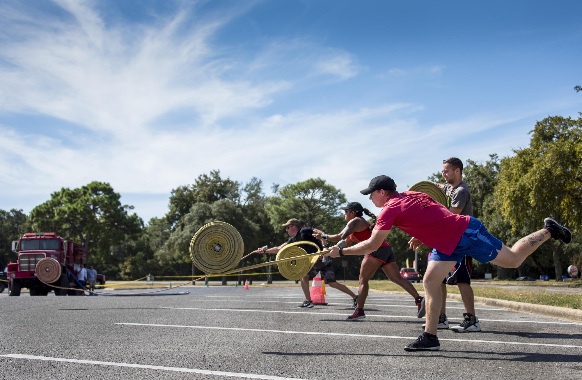 The 86th Fighter Weapons Squadron team unfurl their fire hoses during the fire muster challenge Oct. 14 at Eglin Air Force Base, Fla.  Approximately seven teams competed for the best time in the annual event that included shooting and rolling up the fire hose, hammer sled, victim-carry and water relay. The challenge closed out the base’s Fire Prevention Week activities. (U.S. Air Force photo/Samuel King Jr.)