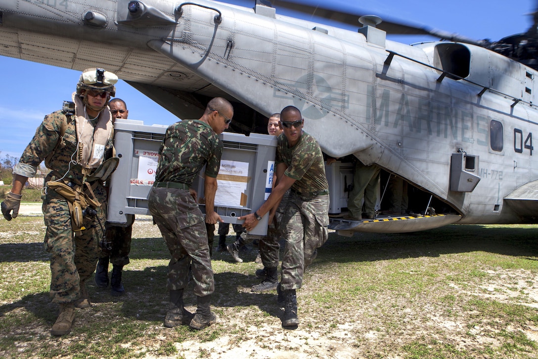 U.S. Marine Corps Sgt. Jordan Becker, left, and Brazilian service members offload a generator from a CH-53E Super Stallion helicopter in Jeremie, Haiti, Oct. 15, 2016. Becker is a cyber network specialist assigned to Joint Task Force Matthew. Marine Corps photo by Sgt. Adwin Esters