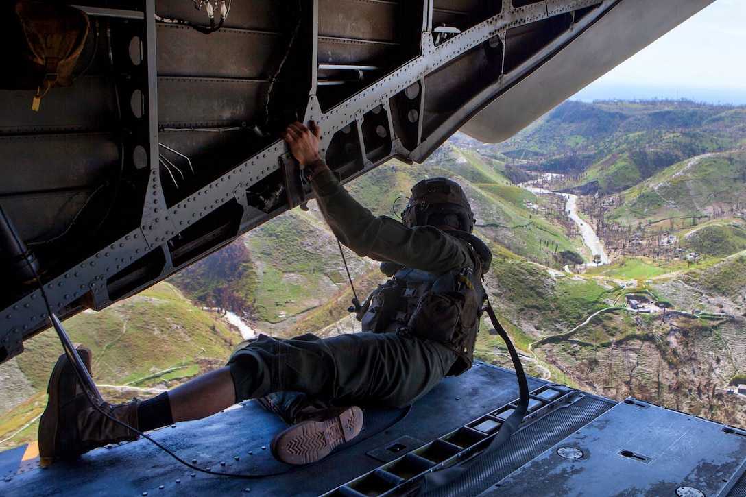 Marine Corps Staff Sgt. Adam Stanley checks for clearance from the ramp of a CH-53E Super Stallion helicopter after delivering supplies in Jeremie, Haiti, Oct. 15, 2016, following Hurricane Matthew. Stanley is a crew chief assigned to Joint Task Force Matthew. Marine Corps photo by Sgt. Adwin Esters