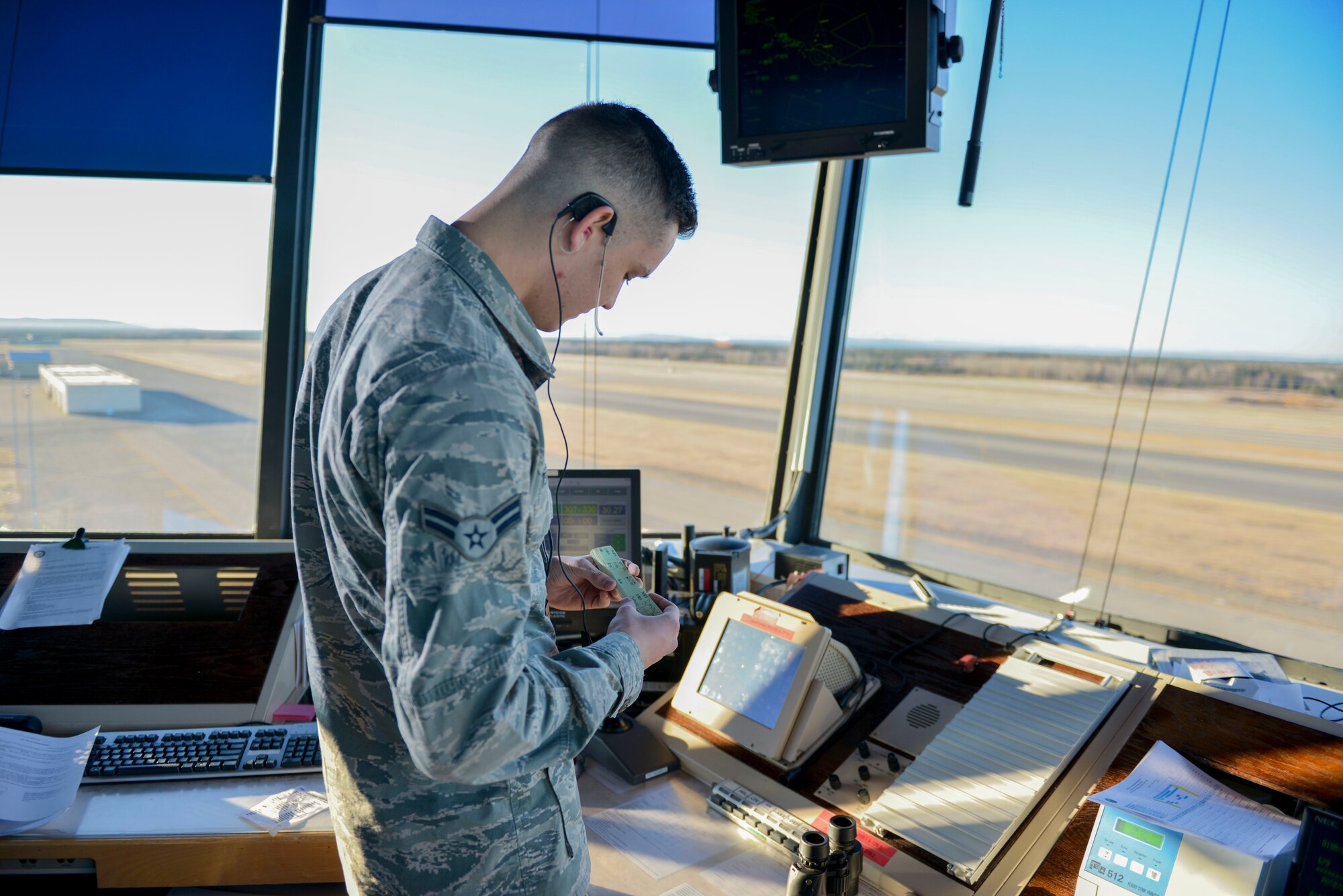 U.S. Air Force Airman 1st Class Kevin Winter Molins, a 354th Operations Support Squadron air traffic control apprentice, checks flight progress strips Oct. 6, 2016, at Eielson Air Force Base, Alaska. Flight progress strips have information such as the departure and arrival times for aircraft. (U.S. Air Force photo by Airman Isaac Johnson)