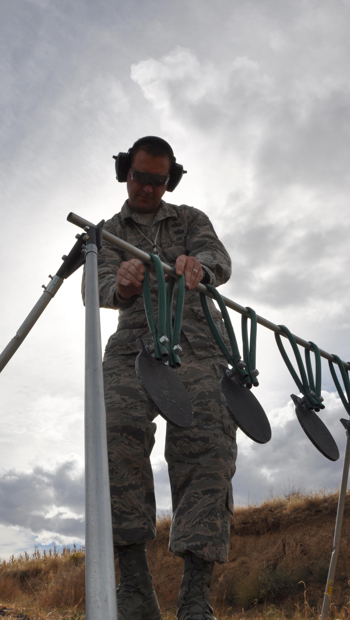 Master Sgt. Derek Perrault, Air Reserve Personnel Center training manager, situates his homemade targets before pistol practice at a firing range in Watkins, Colo., Oct. 3. Perrault earned his U.S. Air Force Elementary Excellence in Competition (EIC) Pistol Badge during a firearm match at the Air Force Academy in Colorado Springs, Colo., in September. (U.S. Air Force photo by Tech. Sgt. Beth Anschutz)