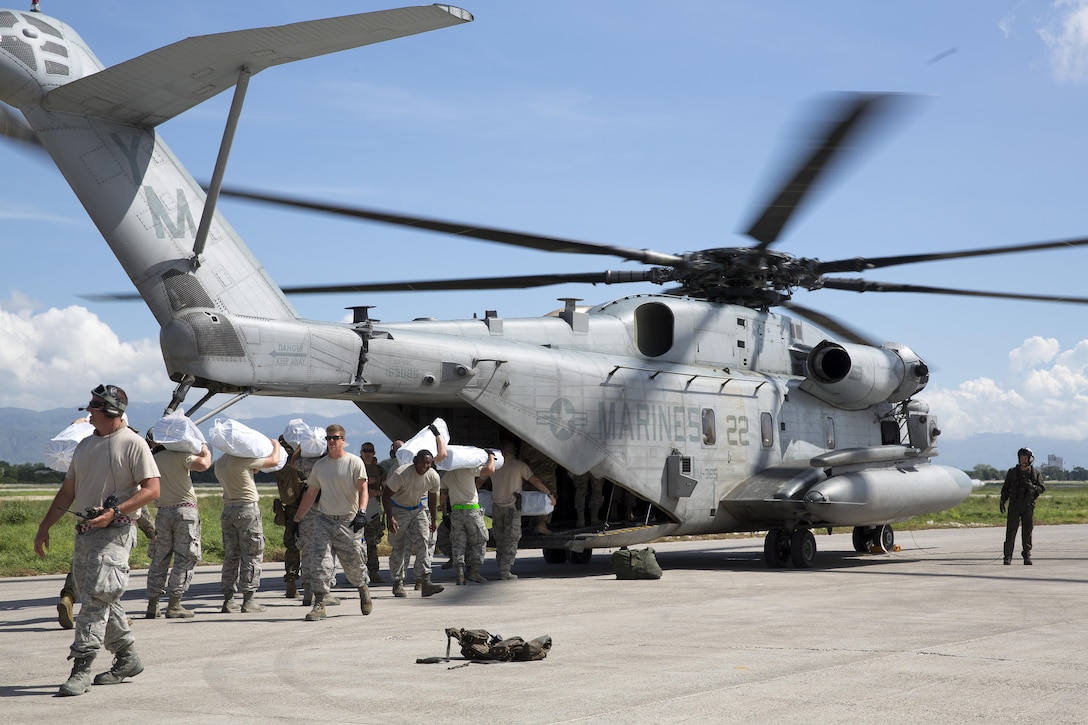 U.S. service members load United States Agency for International Development-provided supplies onto a CH-53E Super Stallion helicopter at Port-au-Prince, Haiti, Oct 16, 2016. The Marines and sailors with the 24th Marine Expeditionary Unit aboard the USS Iwo Jima have been providing assistance to the U.S. government’s civil humanitarian aid and disaster relief efforts in Haiti in the wake of Hurricane Matthew.  Marine Corps photo by Cpl. Hernan Vidana