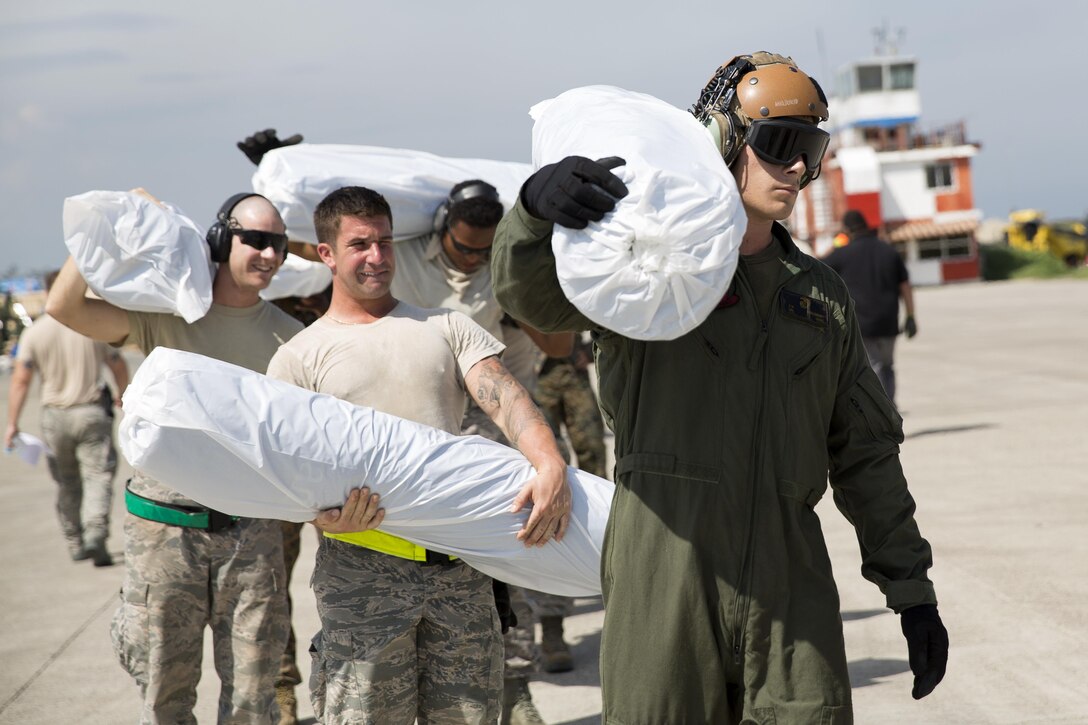 U.S. service members load United States Agency for International Development relief supplies onto a CH-53E Super Stallion helicopter at Port-au-Prince, Haiti, Oct 16, 2016. The Marines and sailors with the 24th Marine Expeditionary Unit aboard the USS Iwo Jima have been providing assistance to the U.S. government’s civil humanitarian aid and disaster relief efforts in Haiti in the wake of Hurricane Matthew. Marine Corps photo by Cpl. Hernan Vidana