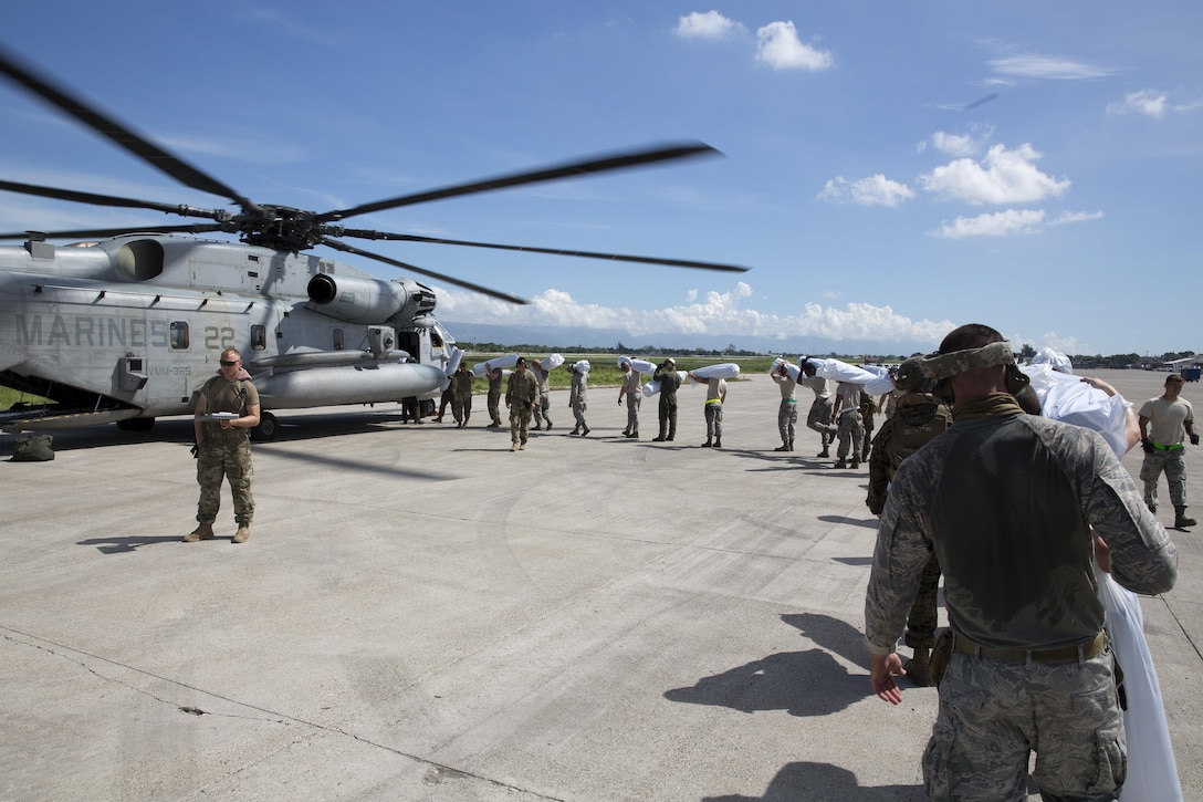 U.S. service members load United States Agency for International Development-provided supplies onto a CH-53E Super Stallion helicopter at Port-au-Prince, Haiti, Oct 16, 2016. The Marines and sailors with the 24th Marine Expeditionary Unit aboard the USS Iwo Jima have been providing assistance to the U.S. government’s civil humanitarian aid and disaster relief efforts in Haiti in the wake of Hurricane Matthew.  Marine Corps photo by Cpl. Hernan Vidana