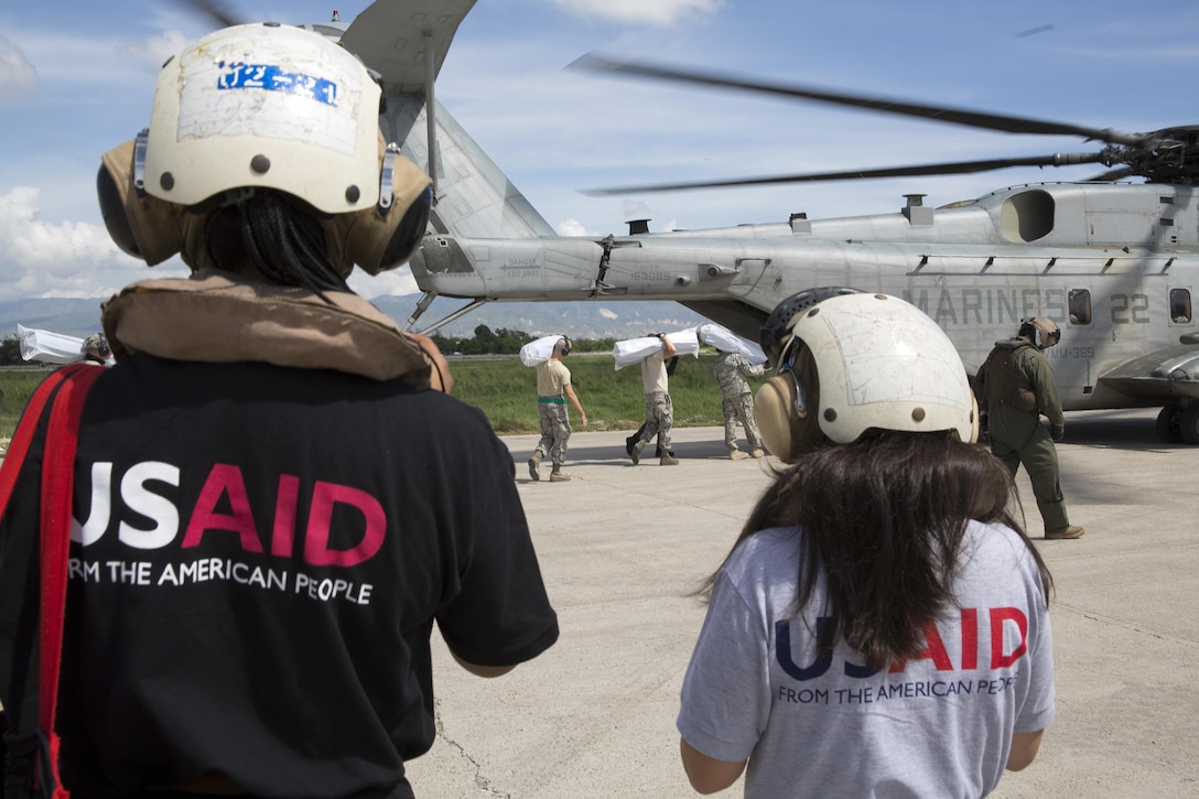 Members from the United States Agency for International Development’s Disaster Assistance Response Team watch U.S. service members load relief supplies onto a CH-53E Super Stallion helicopter at Port-au-Prince, Haiti, Oct 16, 2016. The Marines and sailors with the 24th Marine Expeditionary Unit aboard the USS Iwo Jima have been providing assistance to the U.S. government’s civil humanitarian aid and disaster relief efforts in Haiti in the wake of Hurricane Matthew. Marine Corps photo by Cpl. Hernan Vidana