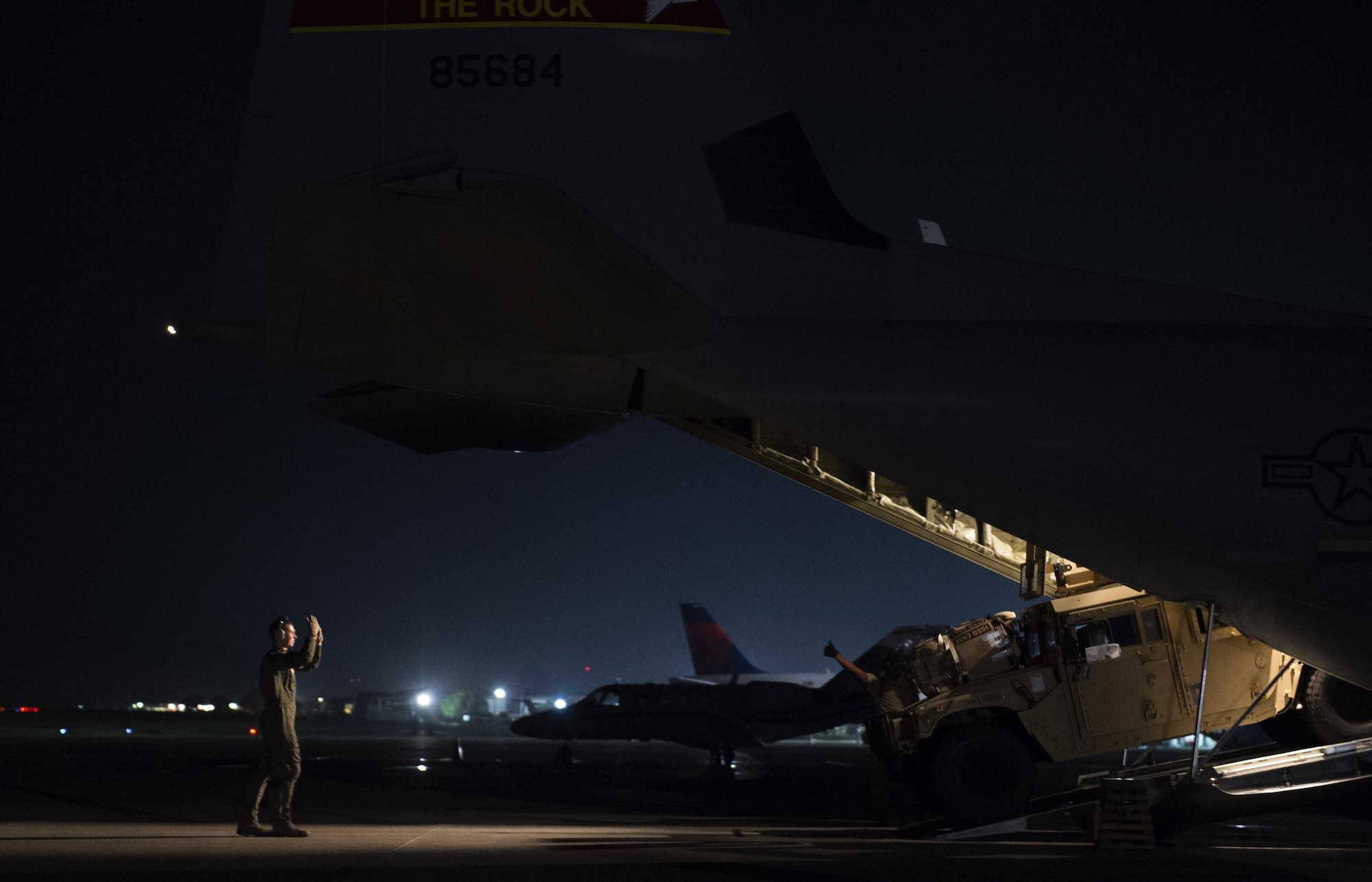 Staff Sgt. Michael Henry, a 61st Airlift Squadron loadmaster, guides the removal of a pallet out of a C-130J Super Hercules on an airstrip in Port-au-Prince, Haiti, Oct. 9, 2016. Airmen from the 61st AS worked alongside several other units in Haiti to support humanitarian relief efforts. (U.S. Air Force photo/Staff Sgt. Paul Labbe)