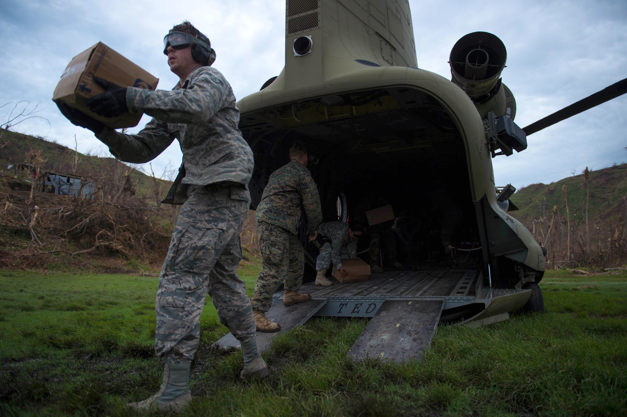 Airman 1st Class James Raynor, a 621st Contingency Response Wing air transportation apprentice, pitches a box during an aid transportation mission Oct. 14, 2016 in Anse-d'Hainault, Haiti. Members of Joint Task Force Matthew have been working to provide and bring aid to those in need in Haiti following the aftermath of Hurricane Matthew.  (U.S. Air Force photo/Staff Sgt. Paul Labbe)