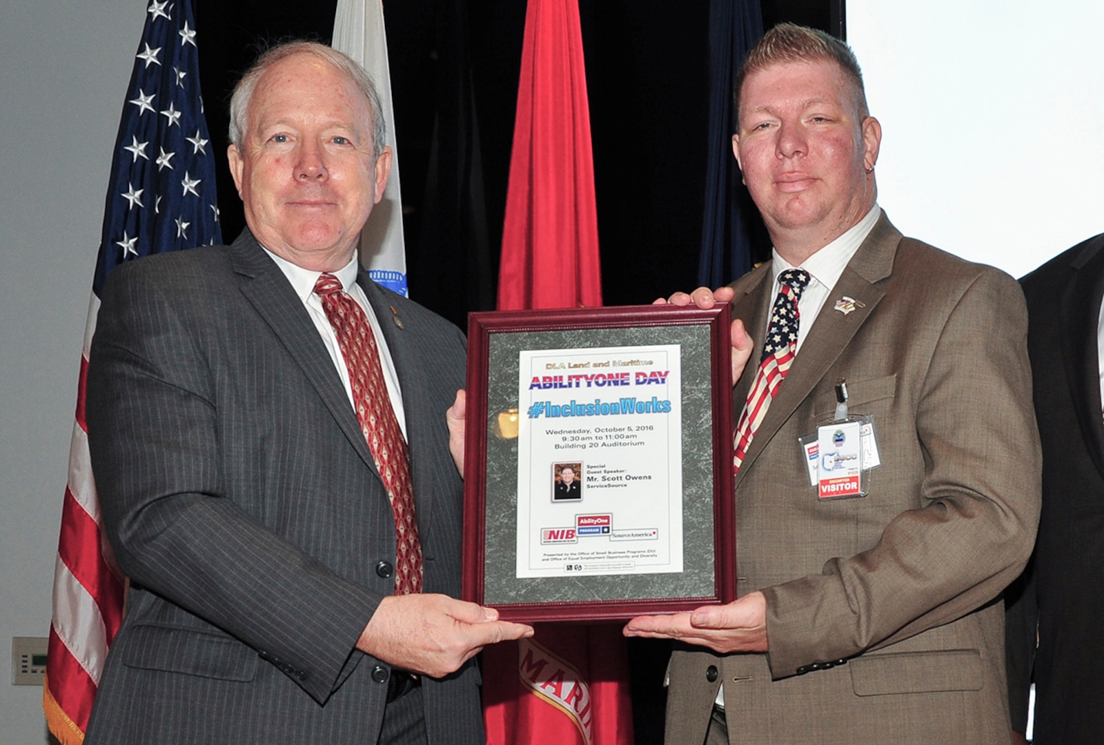 DLA Land and Maritime’s Acting Commander, James McClaugherty (left) presents a framed copy of the AbilityOne Day program to special guest speaker Scott Owens. Owens suffered a Traumatic Brain Injury during a combat tour in Iraq, and now represents AbilityOne through its Speaker's Bureau.