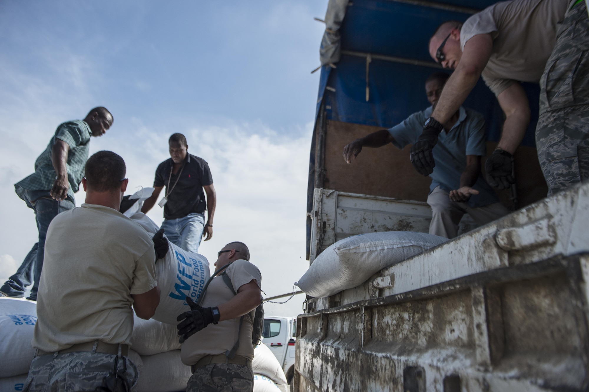 Airmen from the 621st Contingency Response Wing help unload rice from a World Food Program truck Oct. 9, 2016, in Port-Au-Prince, Haiti. The Airmen were working alongside Haitian citizens to provide relief after the nation was struck by Hurricane Matthew. (U.S. Air Force photo/Tech. Sgt. Russ Scalf)