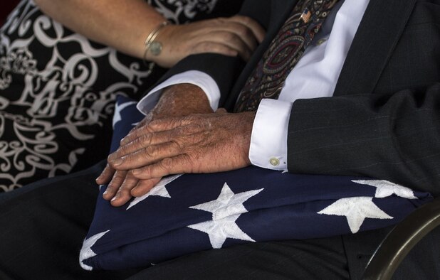 A family member of a fallen military member holds a United States flag during a funeral, Oct. 13, 2016, in Jacksonville, Fla. Once the honor guard has completed all ceremonial honors, the flag is given as a memorial to a family member. (U.S. Air Force photo by Airman 1st Class Janiqua P. Robinson)