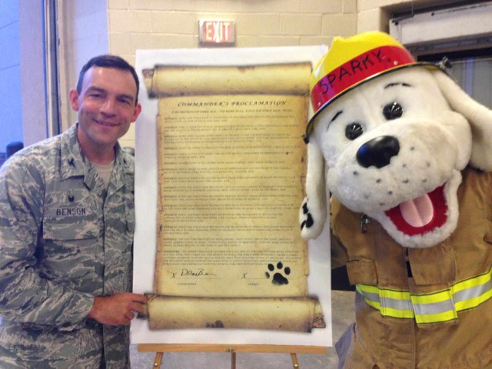 U.S. Air Force Col. David Benson, 7th Bomb Wing commander, and Sparky the Fire Dog, sign the Commander’s Proclamation for fire safety and prevention at Dyess Air Force Base, Texas, Oct. 6, 2016. The Commander’s Proclamation outlined Dyess’ commitment to fire prevention and safety. (Courtesy photo)