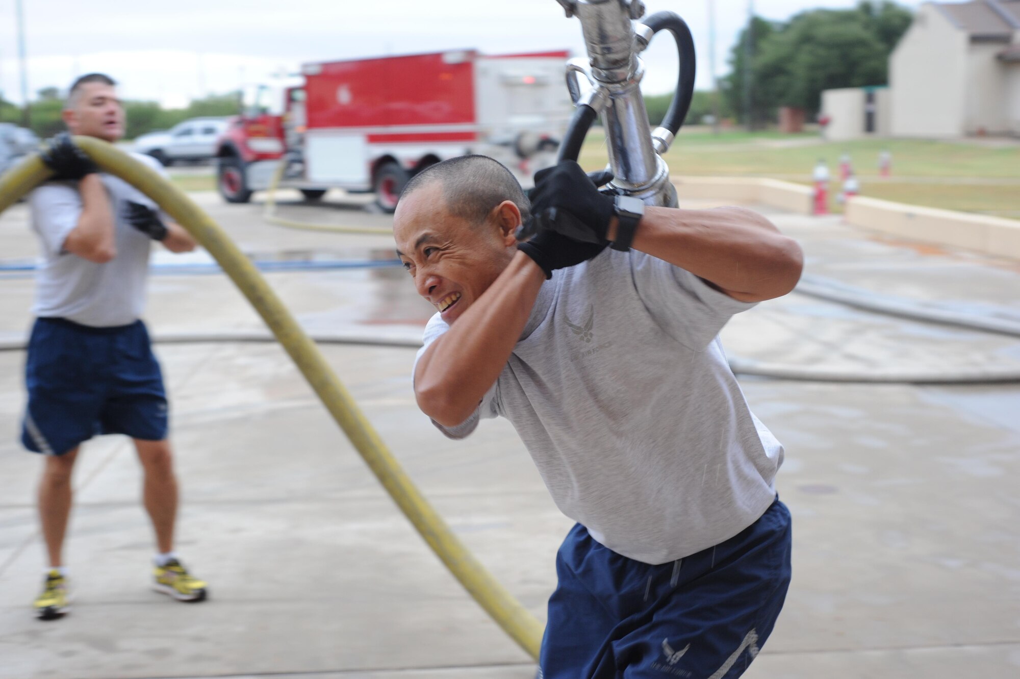 U.S. Air Force Master Sgt. Galli Delfin, 7th Civil Engineer Squadron operations engineering superintendent, carries a hose as part of the Fire Muster at Dyess Air Force Base, Texas, Oct. 14, 2016. The Fire Muster, as part of Fire Prevention Week, was designed to give participating Airmen an opportunity to see what firefighters have to do, from donning the gear to using a high-pressured hose, when responding to an emergency. (U.S. Air Force photo by Airman 1st Class Rebecca Van Syoc)
