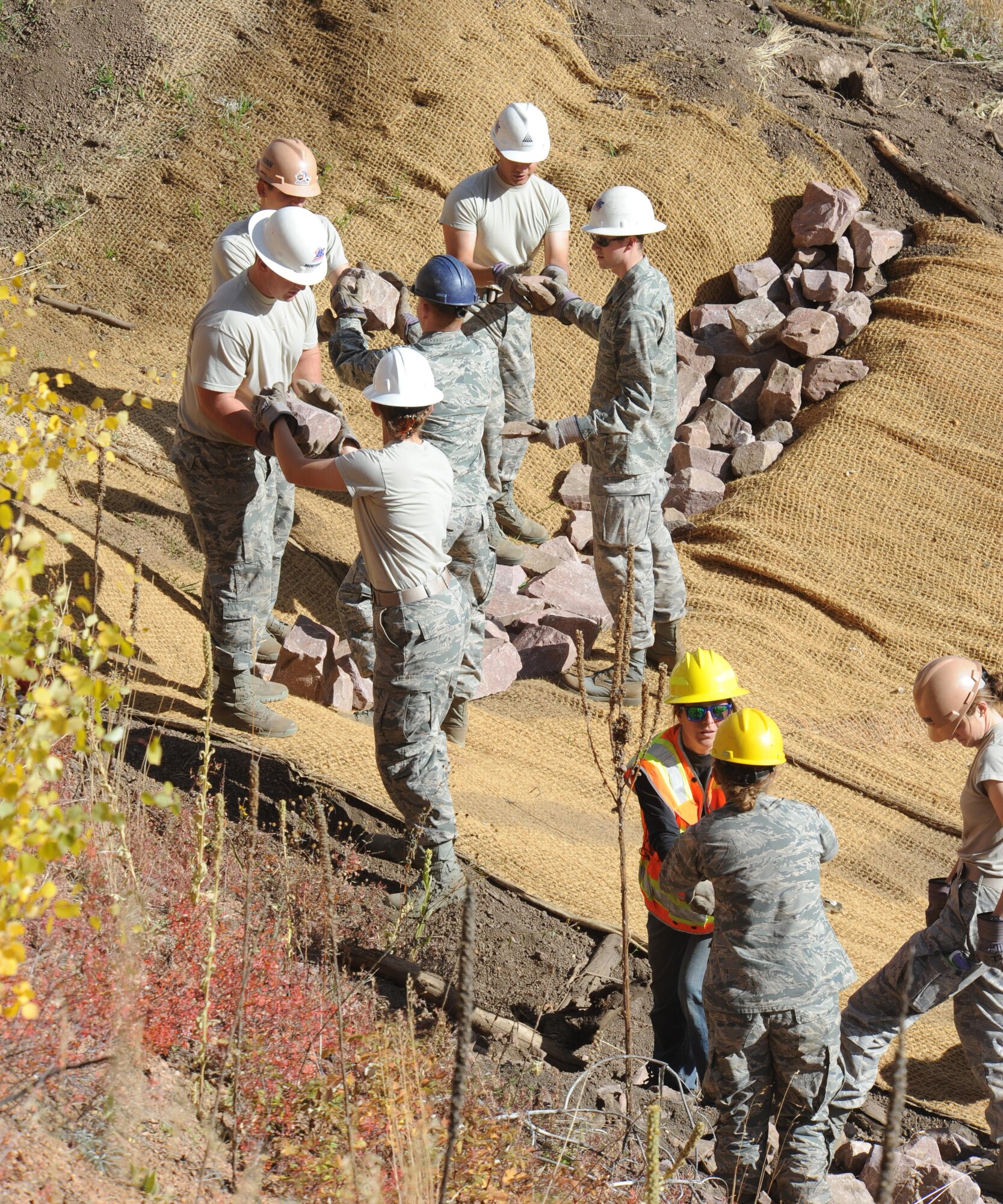Cadets from Cadet Squadron 26, and volunteers from the Coalition for Upper South Platte, move rocks to reinforce a jute barrier to decrease erosion in the Waldo Canyon Burn Scar, Oct. 14, 2016. (U.S. Air Force photo/John Van Winkle)