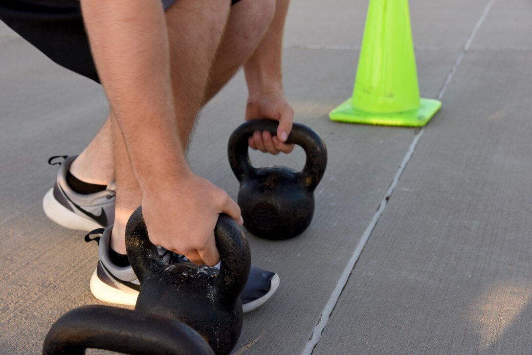 A 3rd Annual Blood, Sweat and Stairs participant grabs kettlebells at the Louis F. Garland Department of Defense Fire Academy on Goodfellow Air Force Base, Texas, during the competition, Oct. 15, 2016. Competitors had to complete various physical challenges during the course to include running up and down flights of stairs, pushups and rope pulling a fire hose. The competition is held each year to honor the first responders of 9/11, however the 312th TRS rescheduled it this year due to bad weather. (U.S. Air Force photo by Senior Airman Joshua Edwards/Released)