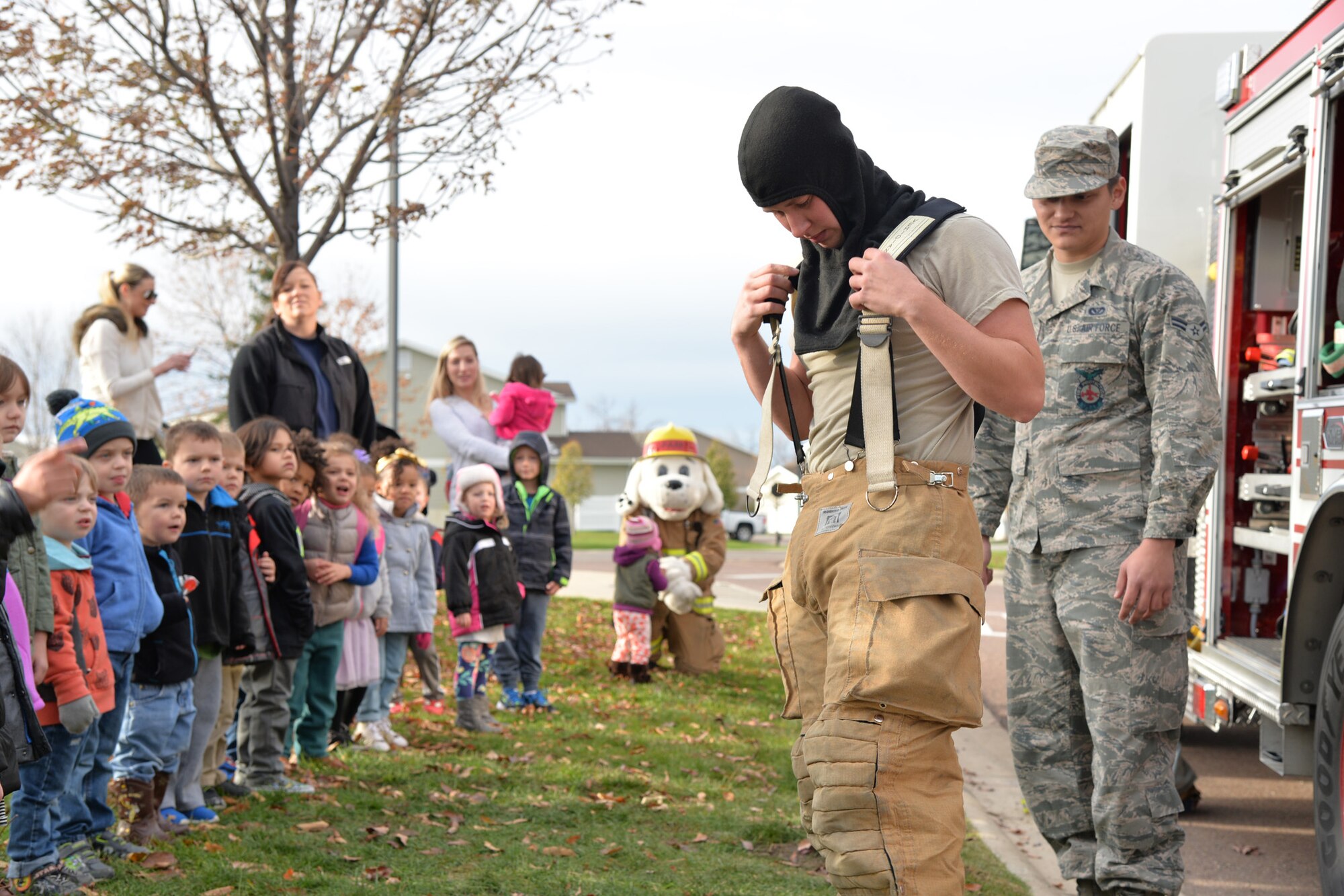 Airmen 1st Class Zachary Hall and Luis Gonzalez, right, 341st Civil Engineer Squadron firefighters, speak to children while visiting the Child Development Center during Fire Prevention Week Oct. 13, 2016, at Malmstrom Air Force Base, Mont. The fire department visited elementary schools and daycares to raise awareness about fire prevention and safety. (U.S. Air Force photo/Airman 1st Class Daniel Brosam)