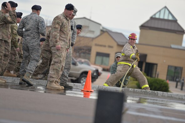 An Airman participates in a fire muster competition during Fire Prevention Week Oct. 14, 2016, at Malmstrom Air Force Base, Mont. The competition tested speed and strength in completing a seven obstacle course. (U.S. Air Force photo/Airman 1st Class Daniel Brosam)