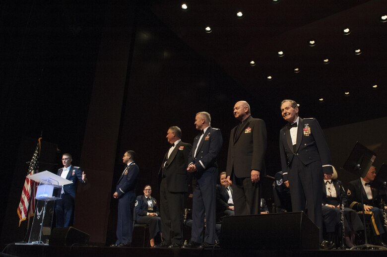 2nd Lt. Philip Emery, U.S. Air Force Heritage of America Band flight commander and associate conductor, left, prepares to coin five generations of conductors who have served with the bands at Joint Base Langley-Eustis over the last 70 years during a USAF HOAB 75th Anniversary Band Concert at the Ferguson Center for the Arts in Newport News, Va., Oct. 1, 2016. For over half a century, the band has represented the Air Force at musical and military events. This concert represents the band’s 75 years of heritage since it was first established in 1941. (U.S. Air Force photo by Staff Sgt. Nick Wilson)