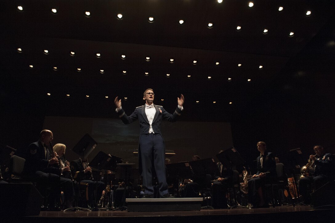 2nd Lt. Philip Emery, U.S. Air Force Heritage of America Band flight commander and associate conductor, guides the audience as they sing “America the Beautiful” during a USAF HOAB 75th Anniversary Band Concert at the Ferguson Center for the Arts in Newport News, Va., Oct. 1, 2016. In addition to the 75th Anniversary of the USAF HOAB, the concert also took place on the one year mark in Emery’s Air Force career. (U.S. Air Force photo by Staff Sgt. Nick Wilson)