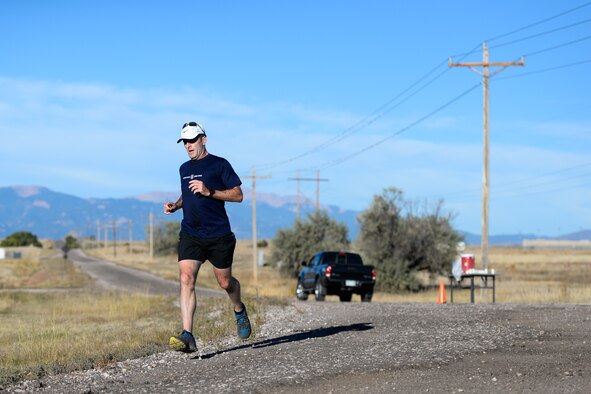 Mike Wasson runs past a water station during the 11th annual Schriever Air Force Base Half Marathon at Schriever Air Force Base, Colorado, Friday, Oct. 14, 2016. Wasson took first place overall with a time of 1:30:59, nearly 10 minutes in front of the second-place finisher. (U.S. Air Force photo/Christopher DeWitt)