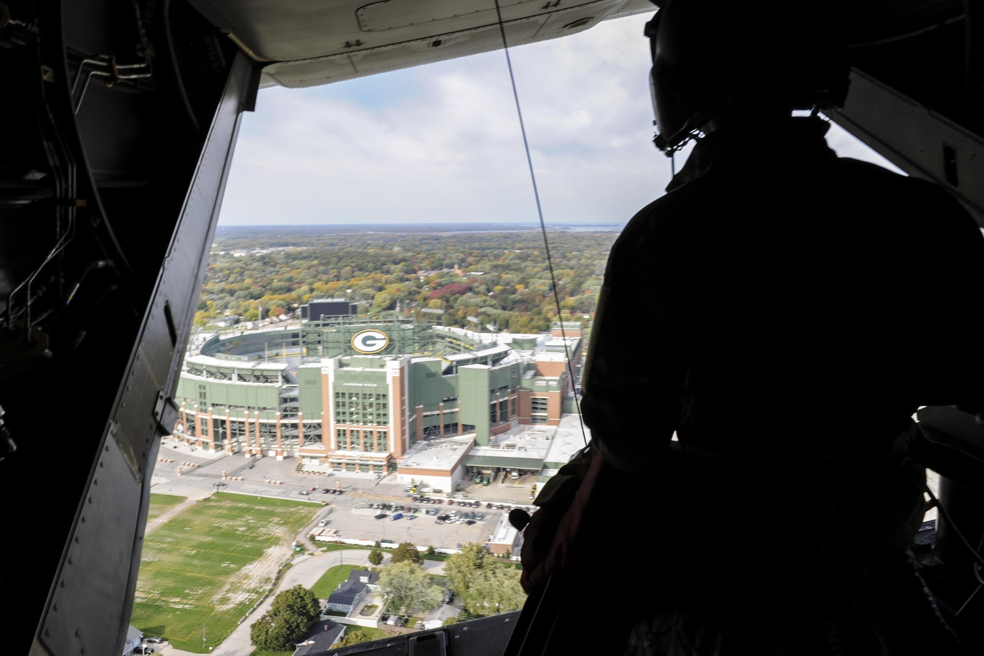 Staff Sgt. Dustin Trevino, a flight engineer with the 8th Special Operations Squadron, looks at Lambeau Field from a CV-22 Osprey tiltrotor aircraft over Green Bay, Wis., Oct. 14, 2016. The 8th SOS visited the Milwaukee-Green Bay area for a flyover above Lambeau Field Oct. 16 during the Green Bay versus Dallas NFL game. The Osprey offers increased speed and range over other rotary-wing aircraft, enabling Air Force Special Operations Command aircrews to execute long-range special operations missions. (U.S. Air Force photo by Airman 1st Class Joseph Pick)