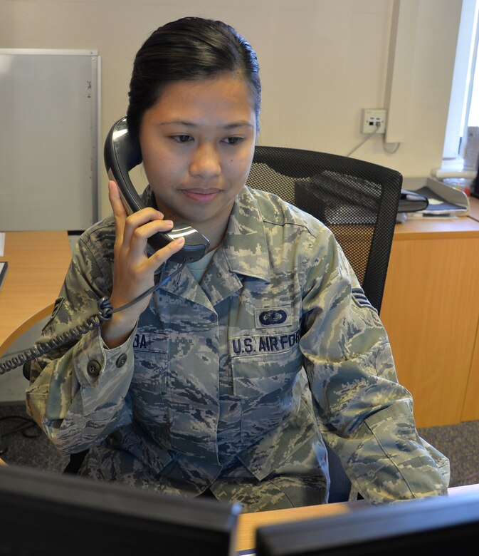 U.S. Air Force Senior Airman Regine Labarda, 100th Comptroller Squadron relocation technician, talks to a customer about his paperwork Oct. 5, 2016, on RAF Mildenhall, England. Labarda stays balanced by painting after work. (U.S. Air Force photo by Gina Randall)