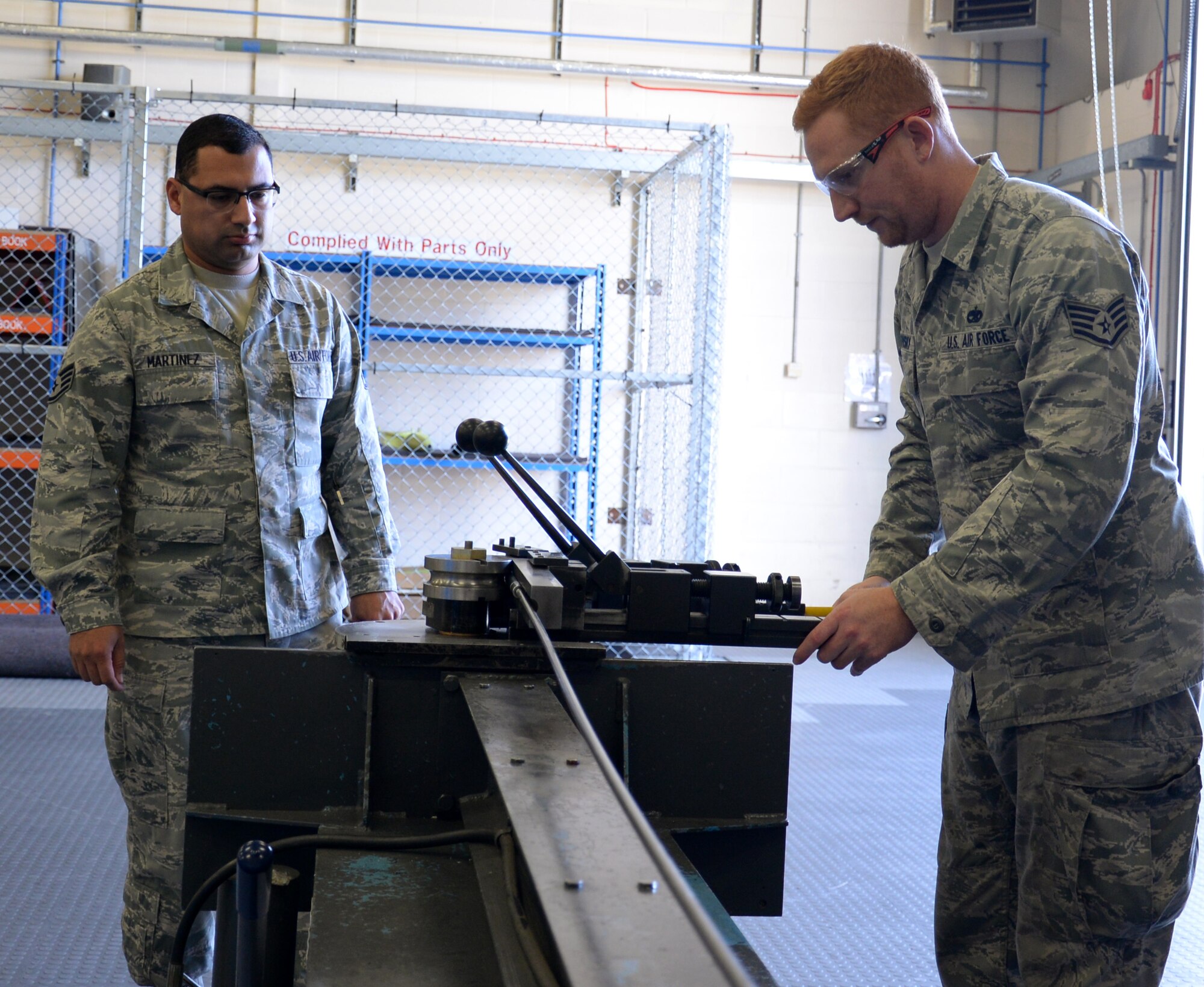U.S. Air Force Staff Sgt. Jose Martinez, left, 100th Air Refueling Wing NCO in charge of inspections and analysis, ensures U.S. Air Force Staff Sgt. Zachary Sidlovsky, 100th Maintenance Squadron Aircraft Structural Maintenance craftsman, uses equipment safely Oct. 17, 2016, on RAF Mildenhall, England. Martinez and the rest of the safety office periodically go into shops to ensure Airmen are following safe procedures. (U.S. Air Force photo by Gina Randall)