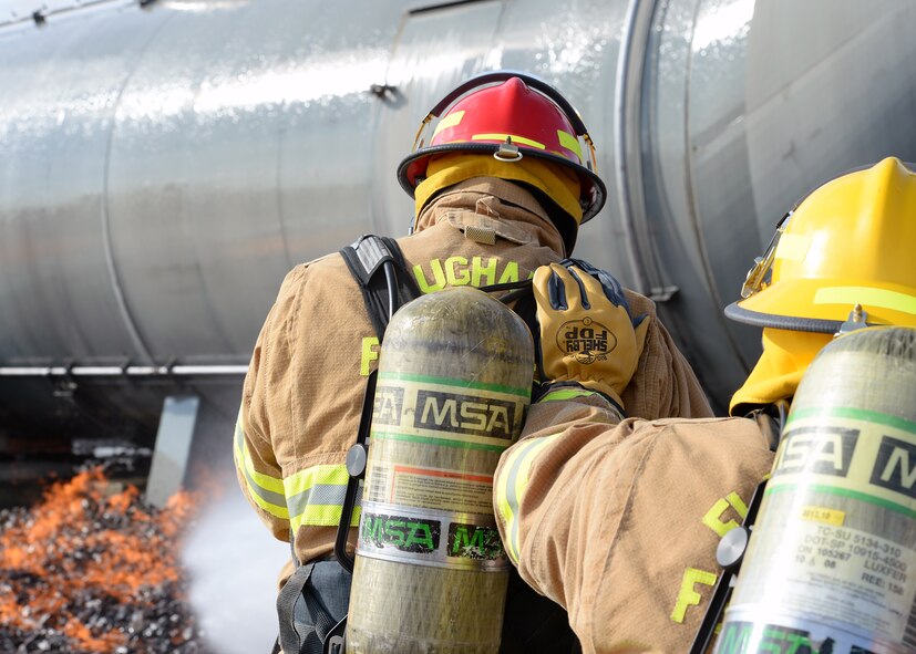 Firefighters hose down flames at a Ramstein Air Base, Germany, Oct. 13, 2016. Firefighting gear can withstand more than 1200 degrees Fahrenheit to protect firefighters. (U.S. Air Force photo by Senior Airman Jimmie D. Pike)