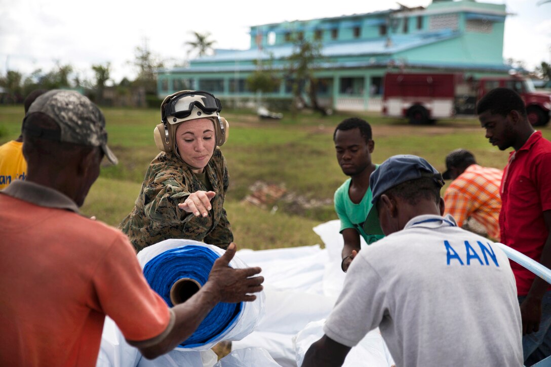 Marine Corps Gunnery Sgt. Brianna Conway, center, and Haitian volunteers unload supplies from a CH-53 Super Stallion helicopter at Les Cayes, Haiti, Oct. 17, 2016. Conway is assigned to the 24th Marine Expeditionary Unit. Marine Corps photo by Cpl. Brianna Gaudi