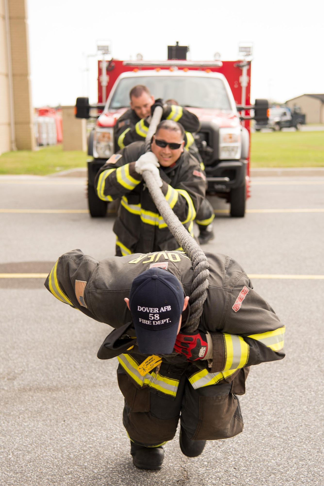 Firefighters from the 436th Civil Engineer Squadron Fire Department pull an emergency vehicle during the 2016 Fire Muster competition Oct. 13, 2016, on Dover Air Force Base, Del. The Fire Department hosts the yearly competition during Fire Prevention Week. (U.S. Air Force photo by Mauricio Campino)