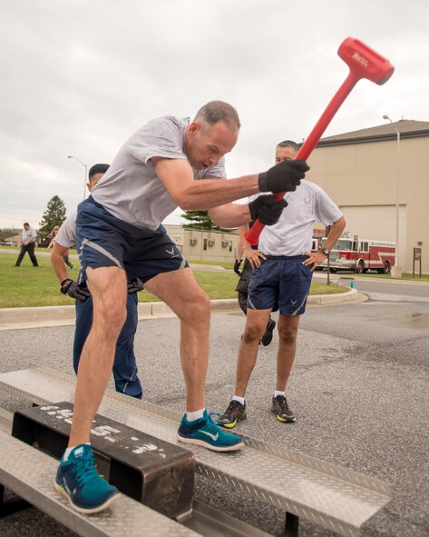 Chief Master Sgt. Michael Zimmerman, 436th Mission Support Group superintendent, swings a sledgehammer at a Keiser sled during the 2016 Fire Muster competition Oct. 13, 2016, on Dover Air Force Base, Del. The force needed to move the sled simulates the force needed for firefighters to forcibly enter a structure. (U.S. Air Force photo by Mauricio Campino)
