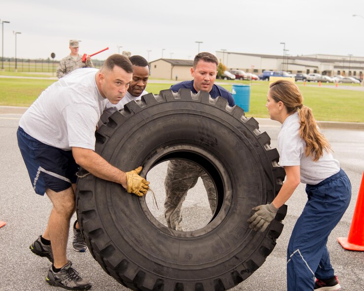 The Chiefs Group team flips a truck tire towards the finish line during the 2016 Fire Muster competition Oct. 13, 2016, on Dover Air Force Base, Del. Teams had to complete seven physical challenges simulating tasks performed by firefighters during emergencies. (U.S. Air Force photo by Mauricio Campino)