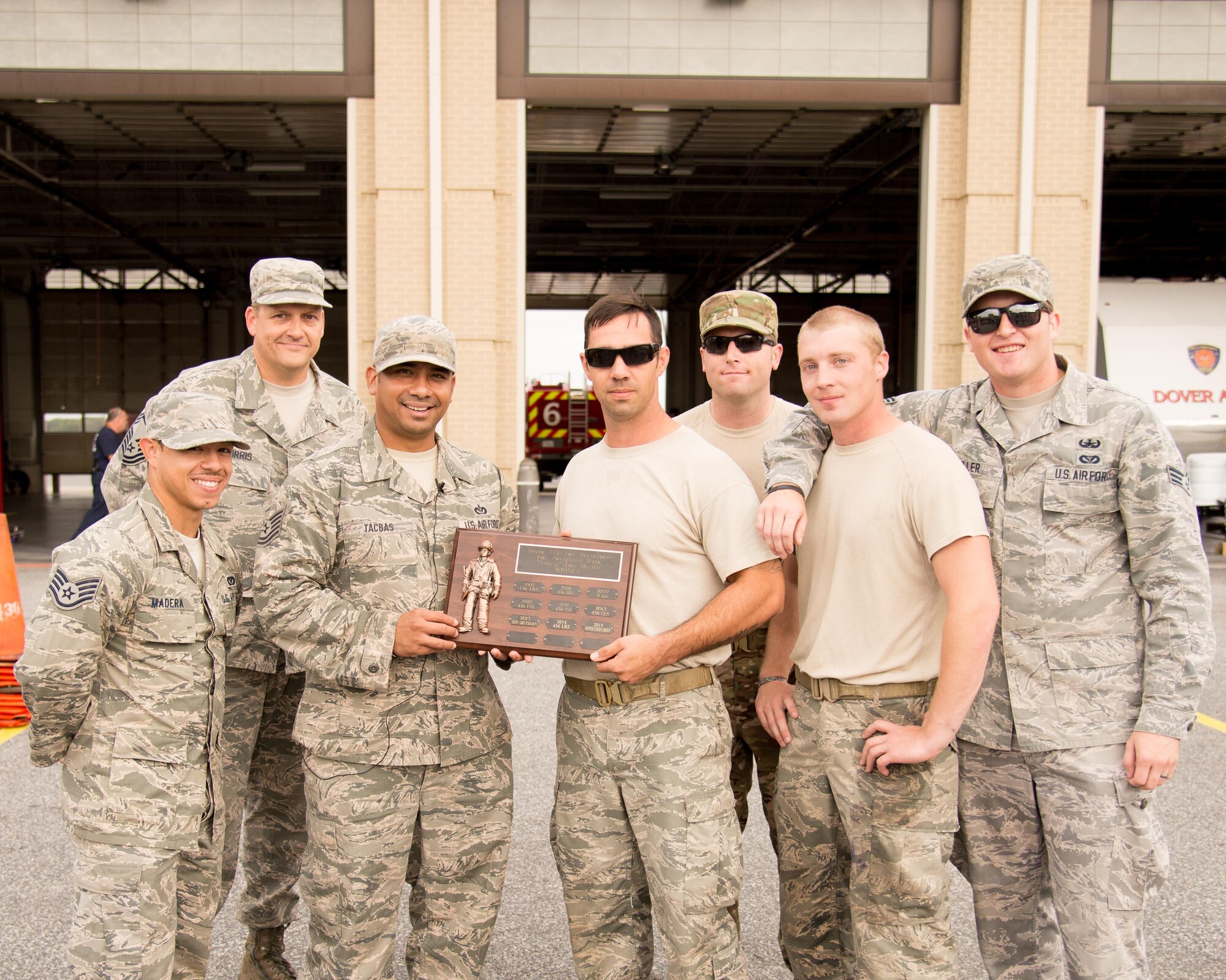 The winning team from 436th Civil Engineer Squadron Explosive Ordnance Disposal poses for a group photo with a plaque at the conclusion of the 2016 Fire Muster competition Oct. 13, 2016, on Dover Air Force Base, Del. The team won the muster competition with a time of 3:34. (U.S. Air Force photo by Mauricio Campino)