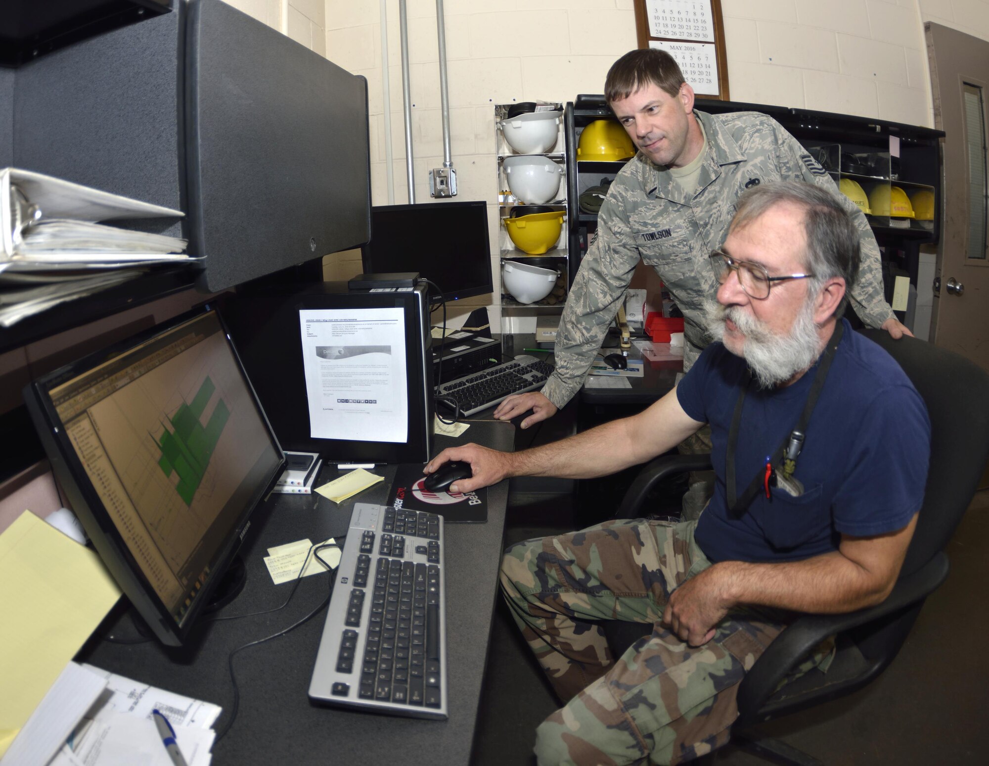 Tech. Sgt. Richard Towlson and Mr. Gary Surozenski check thousands of lines of code on their CAD computer that is used to give instructions to the milling machine. This computer and data put into the CAD program is the first step in building a new part for the C-5.