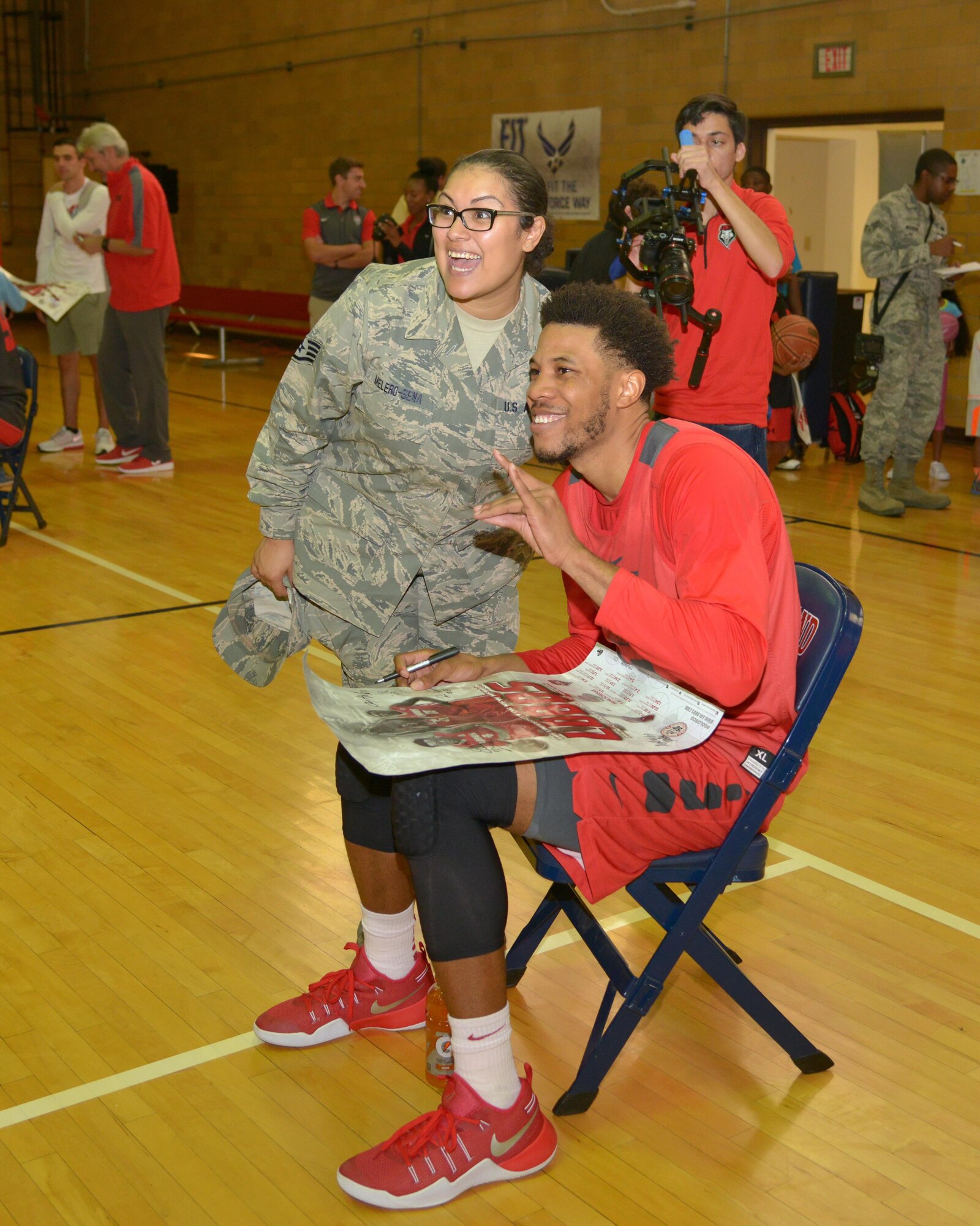 Staff Sgt. Diane Melero-Sena of the 150th Special Operations wing poses for a photo with Lobos men's basketball player Tim Williams following a scrimmage at the Kirtland East Fitness Center Oct. 15. About 100 fans watched the scrimmage, which was scheduled on base to allow the team to show appreciation to military members. 
