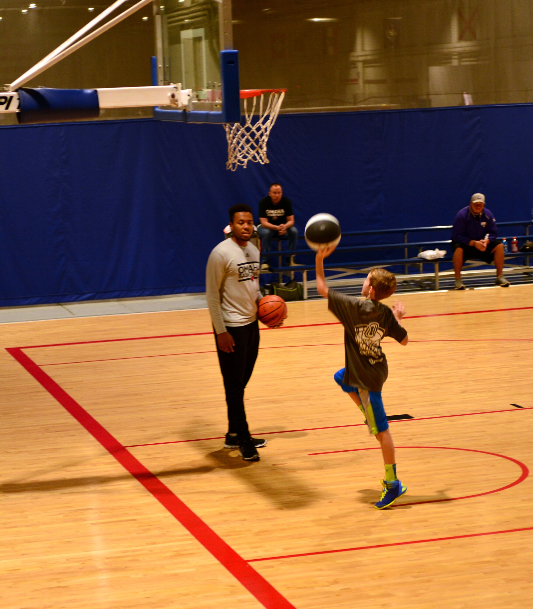 A Team Offutt child works on their off-hand layups under the watchful eye of a University of Nebraska Omaha Mavericks player Oct. 15, 2016 at the Offutt Field House.  The UNO Mavericks’ men’s and women’s basketball teams provided a free basketball clinic to more than 100 military-affiliated children. Nebraska Governor Pete Ricketts spoke to the campers and passed along thanks from the citizens of Nebraska to the members of Team Offutt. 