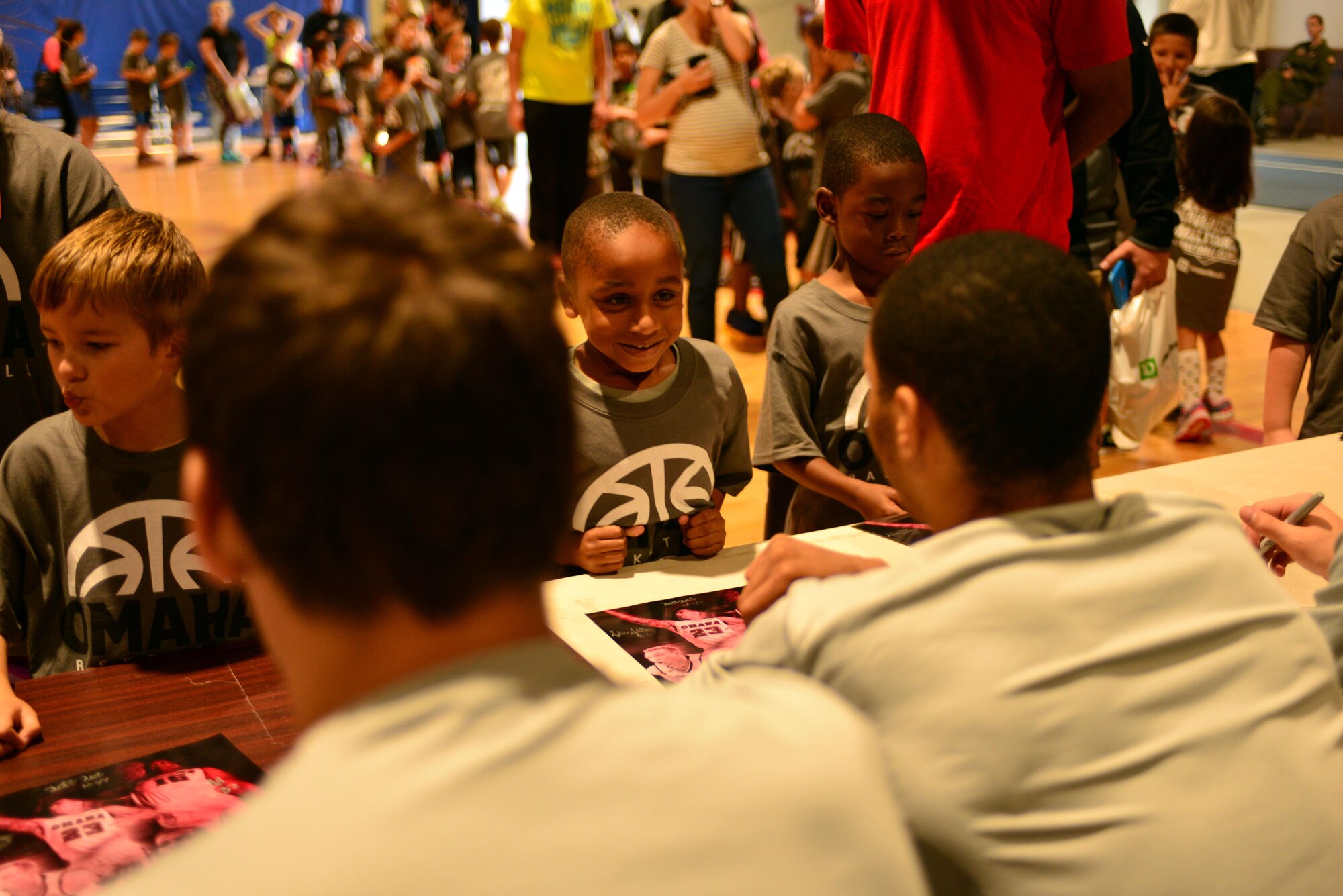 A Team Offutt child seeks an autograph from members of the University of Nebraska Omaha Mavericks men’s and women’s basketball teams Oct. 15, 2016 at the Offutt Field House.  The UNO Mavericks’ men’s and women’s basketball teams provided a free basketball clinic to more than 100 military-affiliated children. Nebraska Governor Pete Ricketts spoke to the campers and passed along thanks from the citizens of Nebraska to the members of Team Offutt. 