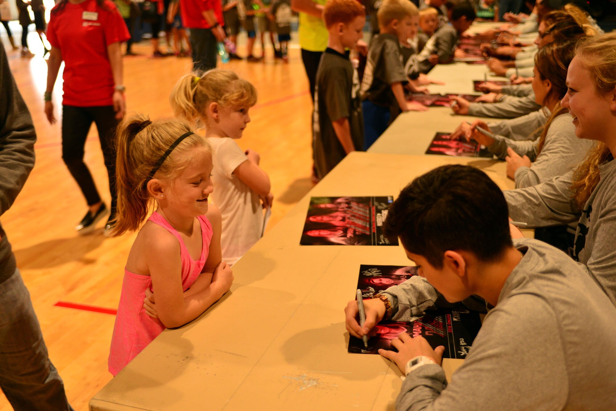 A Team Offutt child seeks an autograph from members of the University of Nebraska Omaha Mavericks men’s and women’s basketball teams Oct. 15, 2016 at the Offutt Field House.  The UNO Mavericks’ men’s and women’s basketball teams provided a free basketball clinic to more than 100 military-affiliated children. Nebraska Governor Pete Ricketts spoke to the campers and passed along thanks from the citizens of Nebraska to the members of Team Offutt. 