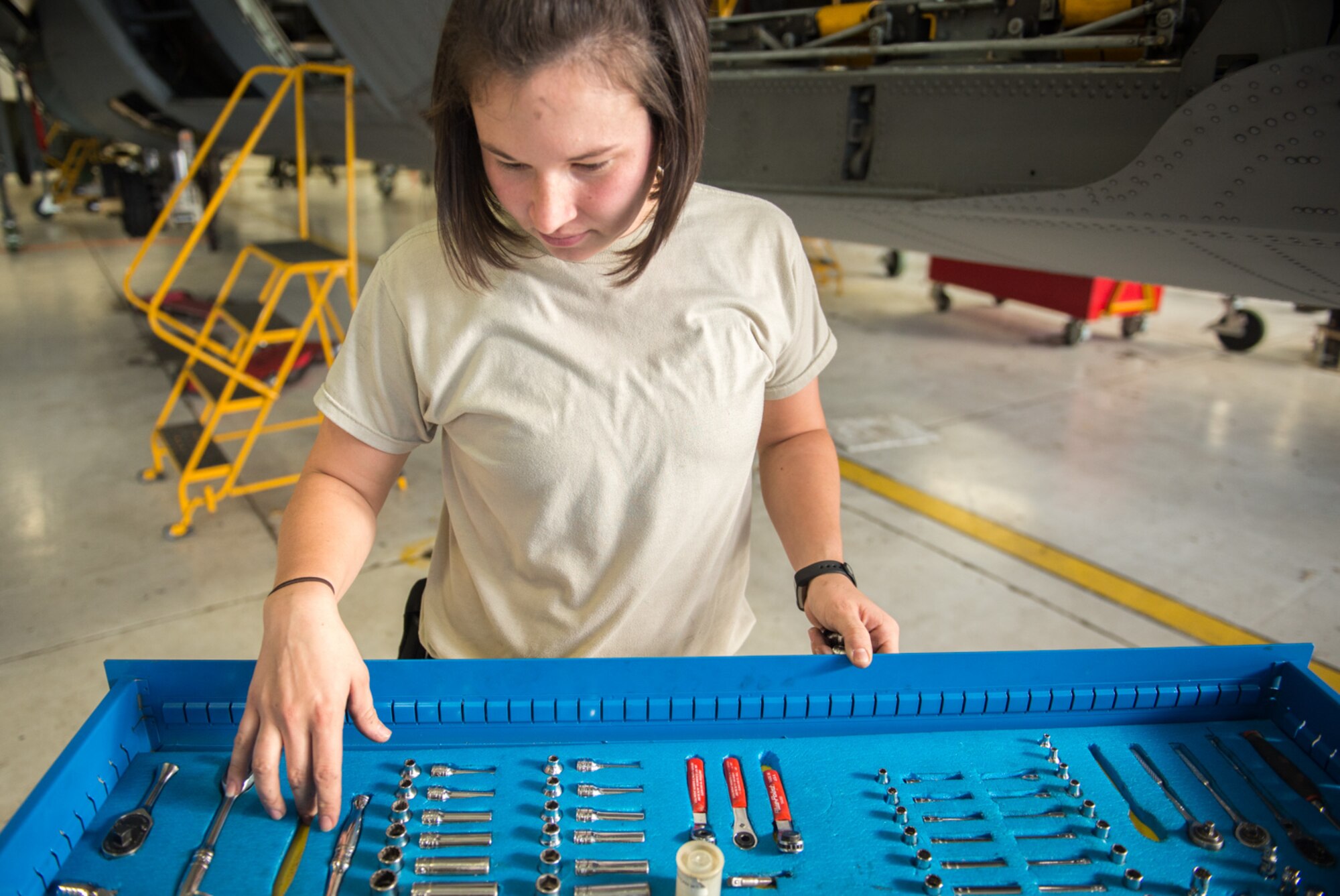 Senior Airman Stephanie Kreofsky, 934th Aircraft Maintenance Squadron, searches for a tool during routine pre-deployment maintenance of a C-130 on October 16. (U.S. AIr Force photo by Tech. Sgt. Trevor Saylor)