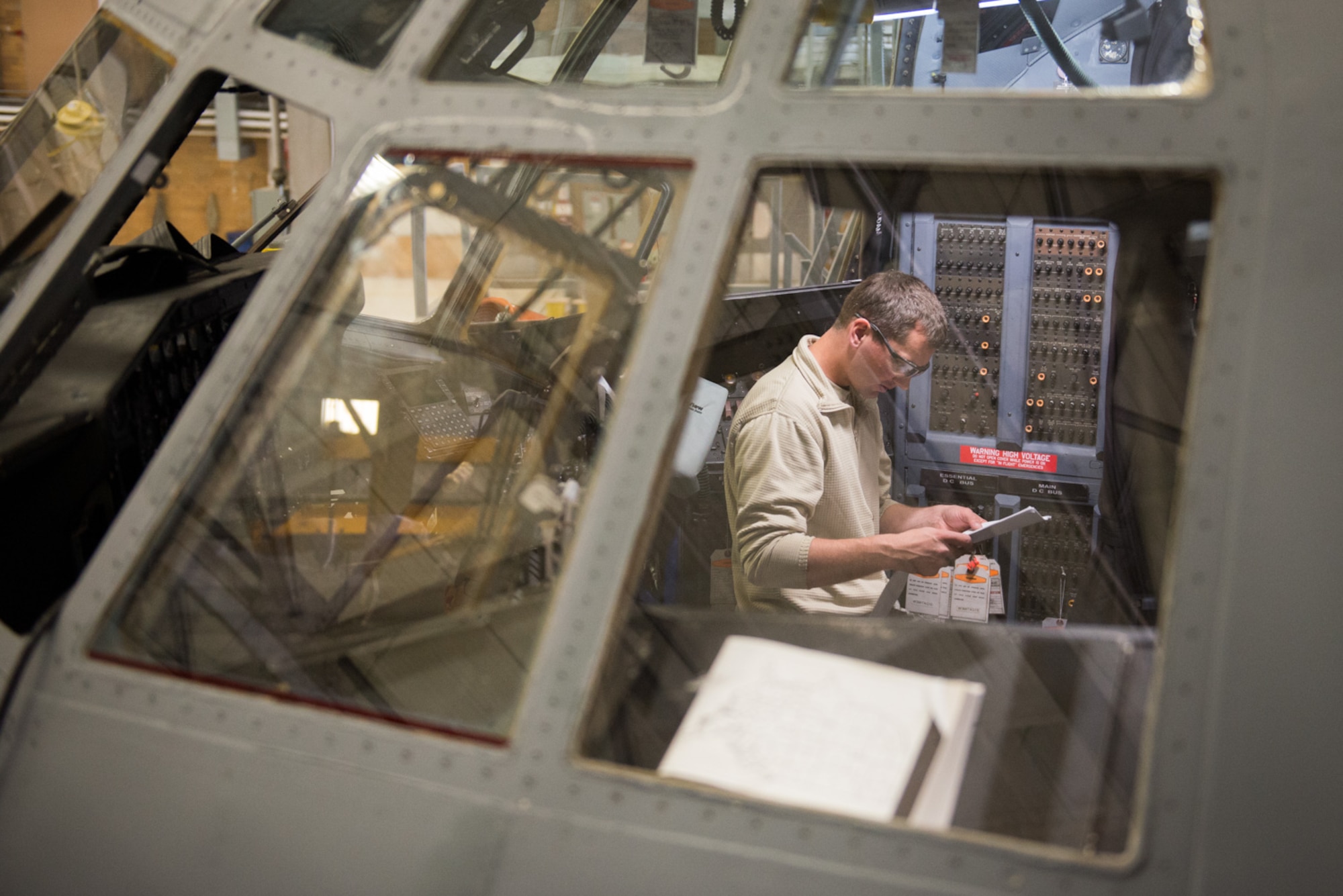 Tech. Sgt. Erik Kvamme, 934th Maintenance Squadon,  consults a manual as he works to install new armor in the flight deck of a C-130. (U.S. Air Force photo by Tech. Sgt. Trevor Saylor)