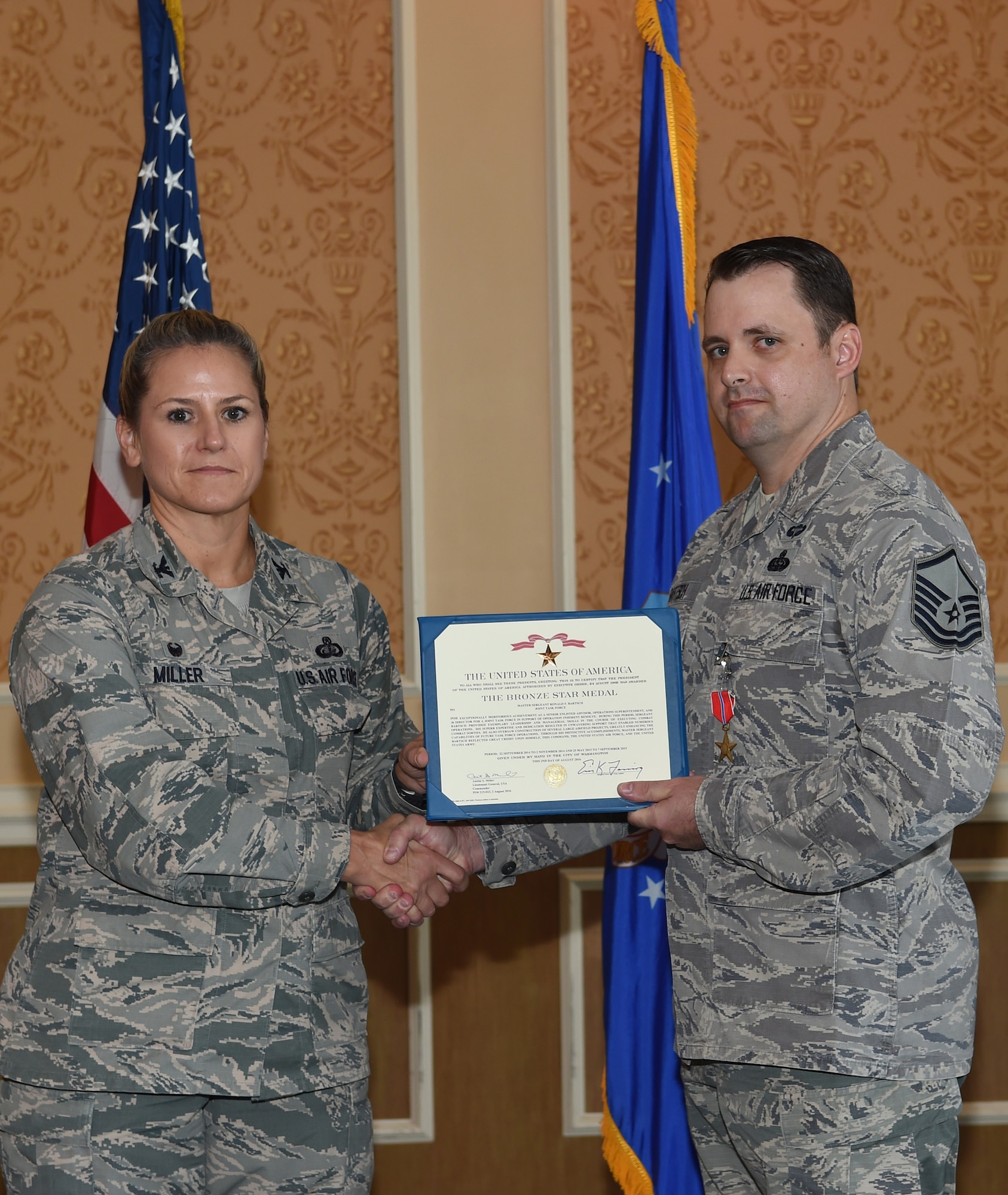 Col. Caroline Miller, 633rd Air Base Wing commander, presents the Bronze Star to Master Sgt. Ronald Bartsch, 633rd Communications Squadron cyber transport superintendent, at Joint Base Langley-Eustis, Va., Oct. 13, 2016. Bartsch was presented with the medal for accomplishments he made as a joint task force operations superintendent, deployed task force communications director a senior enlisted advisor for a Joint Special Operations Air Detachment of 320 service members in support of for Operation Inherent Resolve in Southwest Asia from Sept. 22 to Nov. 2, 2014 and May 25 to Sept. 7, 2015. (U.S. Air Force photo by Staff Sgt. Natasha Stannard)