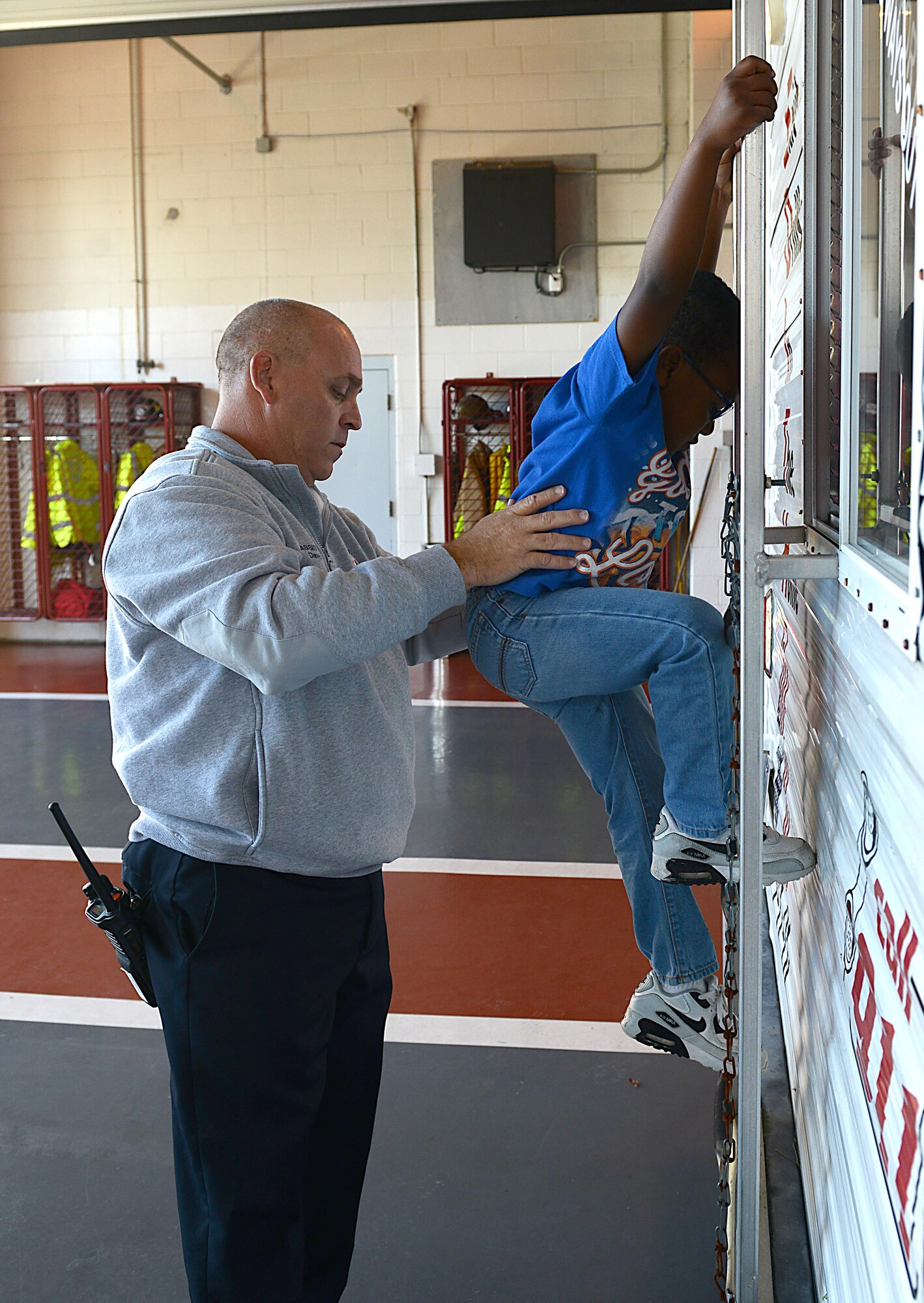 Members of the Fort Eustis Fire and Emergency Services assist children as they practice escaping through a window, in the event of a fire in their homes, during Fire Prevention Week at Joint Base Langley-Eustis, Va., Oct. 15, 2016. Throughout the week, firefighters traveled to local schools, food establishments and hosted an open house in order to educate community members on the importance of preventing and fighting fires. (U.S. Air Force photo by Staff Sgt. Teresa  J. Cleveland)