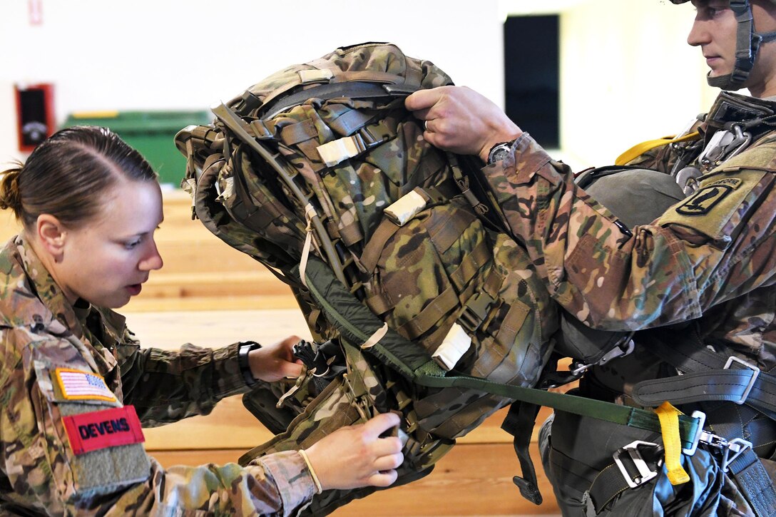 Army Sgt. Hailey Devens, left, performs a jumpmaster personnel equipment inspection on a paratrooper before participating in the Peacemaster Unity airborne operation at Aviano Airbase in Italy, Oct. 17, 2016. Devens is a jumpmaster assigned to the 173rd Airborne Brigade. Hundreds of paratroopers are gathered at Aviano Airbase and simultaneously in Latvia, bringing together several partner and allied nations for one of the largest combined airborne operations. Paratroopers from Hungary, Italy, the Netherlands, Poland, Romania and the United States are taking part in Peacemaster Unity, which is being held Oct. 17-20, 2016, and will culminate with a wing exchange ceremony. The combined exercise demonstrates the multinational capacity building of the airborne community and the airborne allied nations collectively. Army photo by Staff Sgt. Opal Vaughn