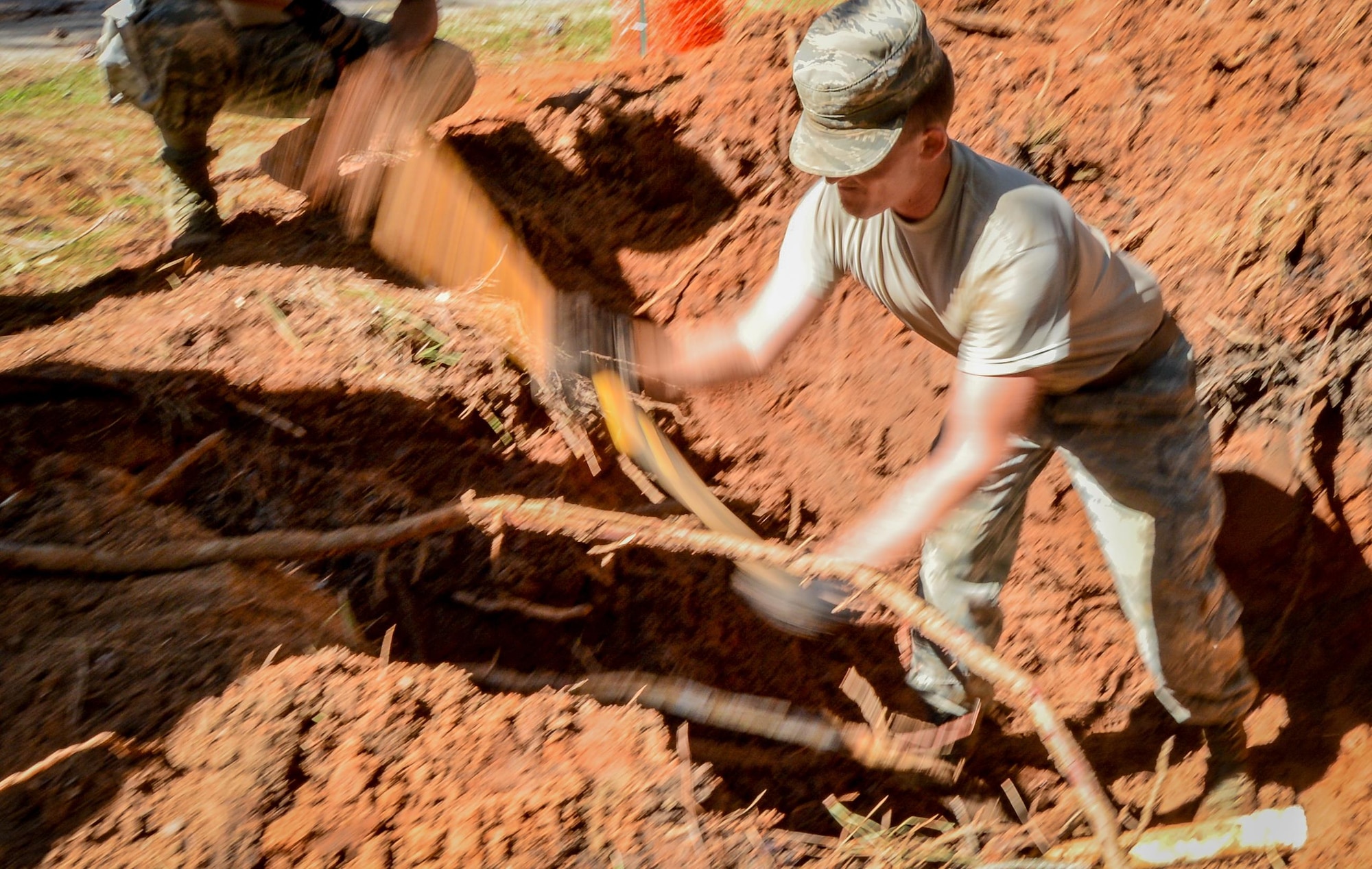U.S. Air Force Senior Airman Eric Lusinger, 20th Civil Engineer Squadron water and fuels apprentice, breaks up roots to prepare the area to fix a broken water pipe at Shaw Air Force Base, S.C., Oct. 13, 2016. Debris and dirt were removed from the area to expose the broken pipe for repair. (U.S. Air Force photo by Senior Airman Diana M. Cossaboom)