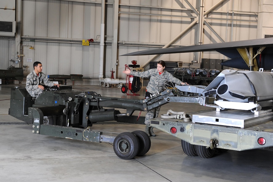 Airman 1st Class Matise Venett, 5th Aircraft Maintenance Squadron load crew member and Staff Sgt. Amanda Cannon, 5th AMXS load crew chief, use a MHU-83 Jammer to move an inert munition during the load crew of the quarter competition at Minot Air Force Base, N.D., Oct. 14, 2016. The competition was comprised of four parts: dress and appearance, consolidated tool inspection, written test and best load. (U.S. Air Force photo/Senior Airman Kristoffer Kaubisch)