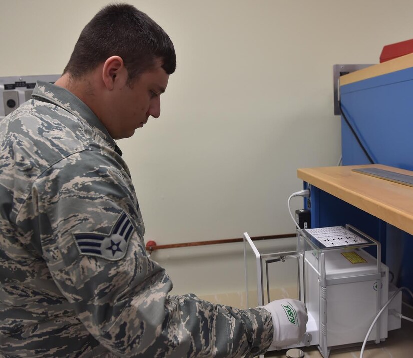 Senior Airman Jack Steinberg, 437th Maintenance Squadron test measurement diagnostic equipment technician, demonstrates the precision of an Analytical Balance AT1004 on Oct. 4, 2016, at Joint Base Charleston, South Carolina. The balance is capable of measuring a written signature accurately. This can be useful for Security Forces and the Office of Special Investigations.