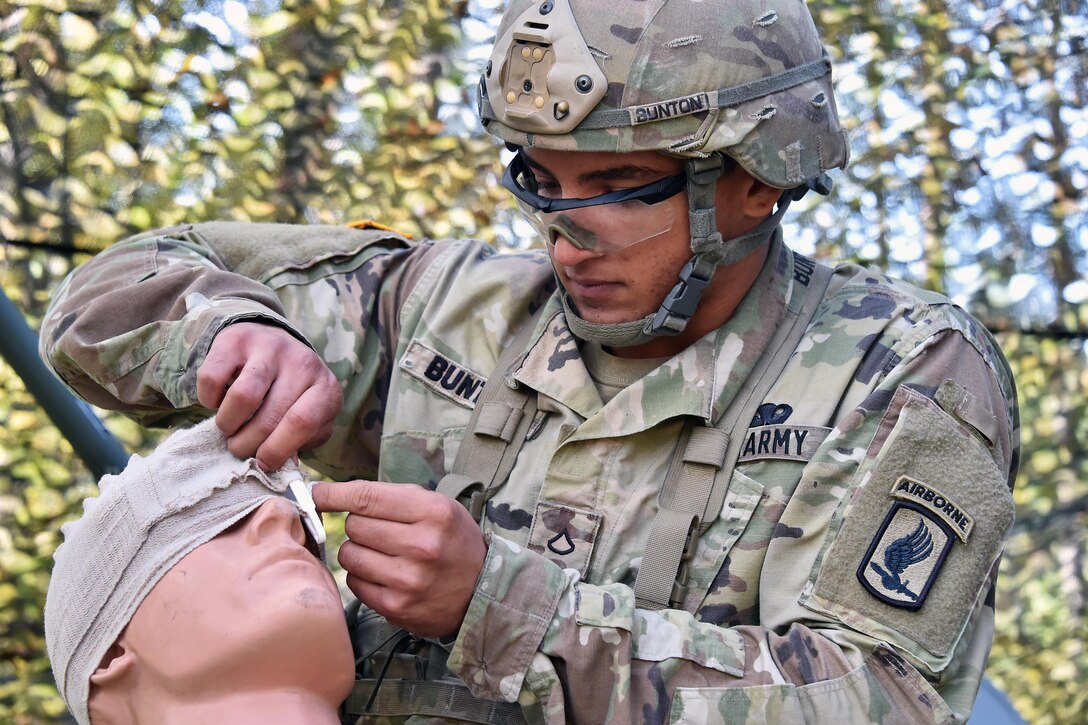 Army Pfc. John Bunton applies first aid to a simulated open head wound during Expert Infantryman Badge training at the 7th Army Training Command’s Grafenwoehr Training Area in Germany, Oct. 17, 2016. The purpose of the Expert Infantryman Badge is to recognize Infantrymen who have demonstrated a mastery of critical tasks that build the core foundation of individual proficiency that enables them to locate, close with, and destroy the enemy through fire and maneuver and repel an enemy assault in close combat. Army photo by Gertrud Zach